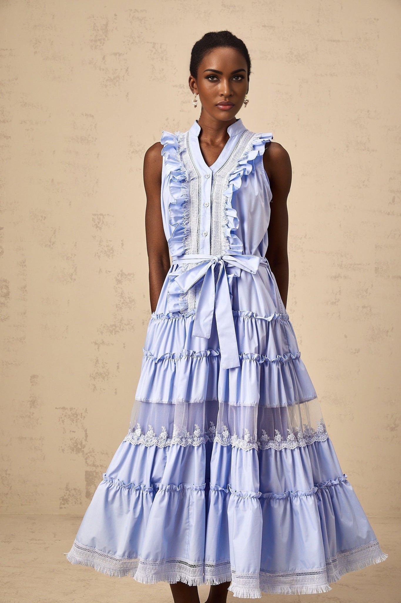 A blue midi dress with ruffles and floral lace trim featuring a tiered skirt design named Olena