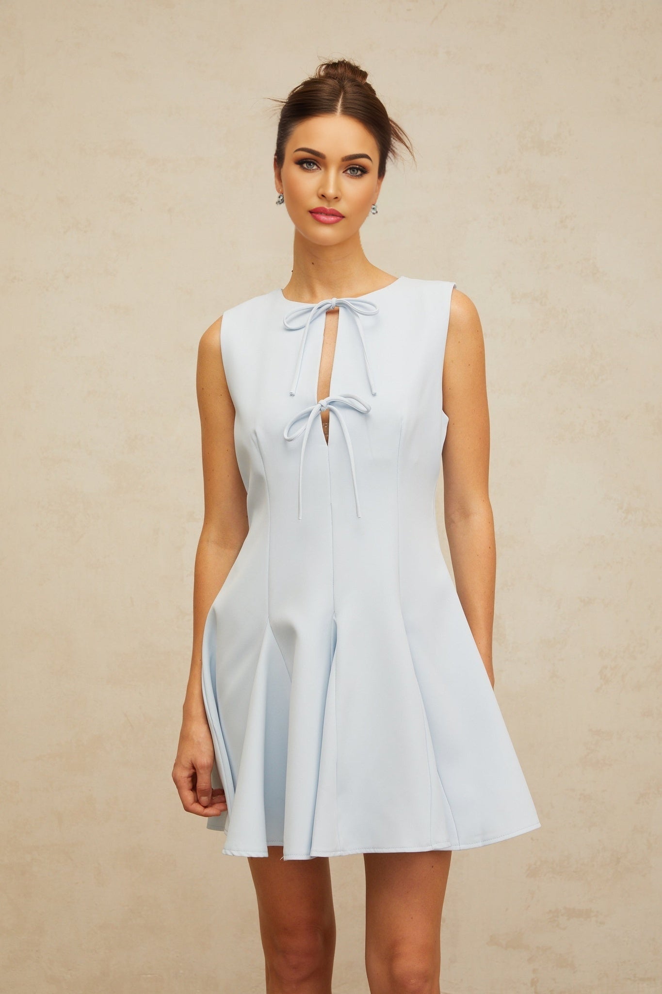 A blue mini dress with a bowknot detail and godet skirt design featuring a flared silhouette and short length