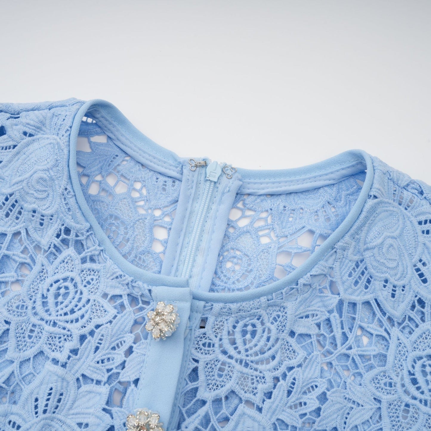 A blue mini dress with floral applique and ruffled lace details featuring a feminine silhouette and delicate embellishments