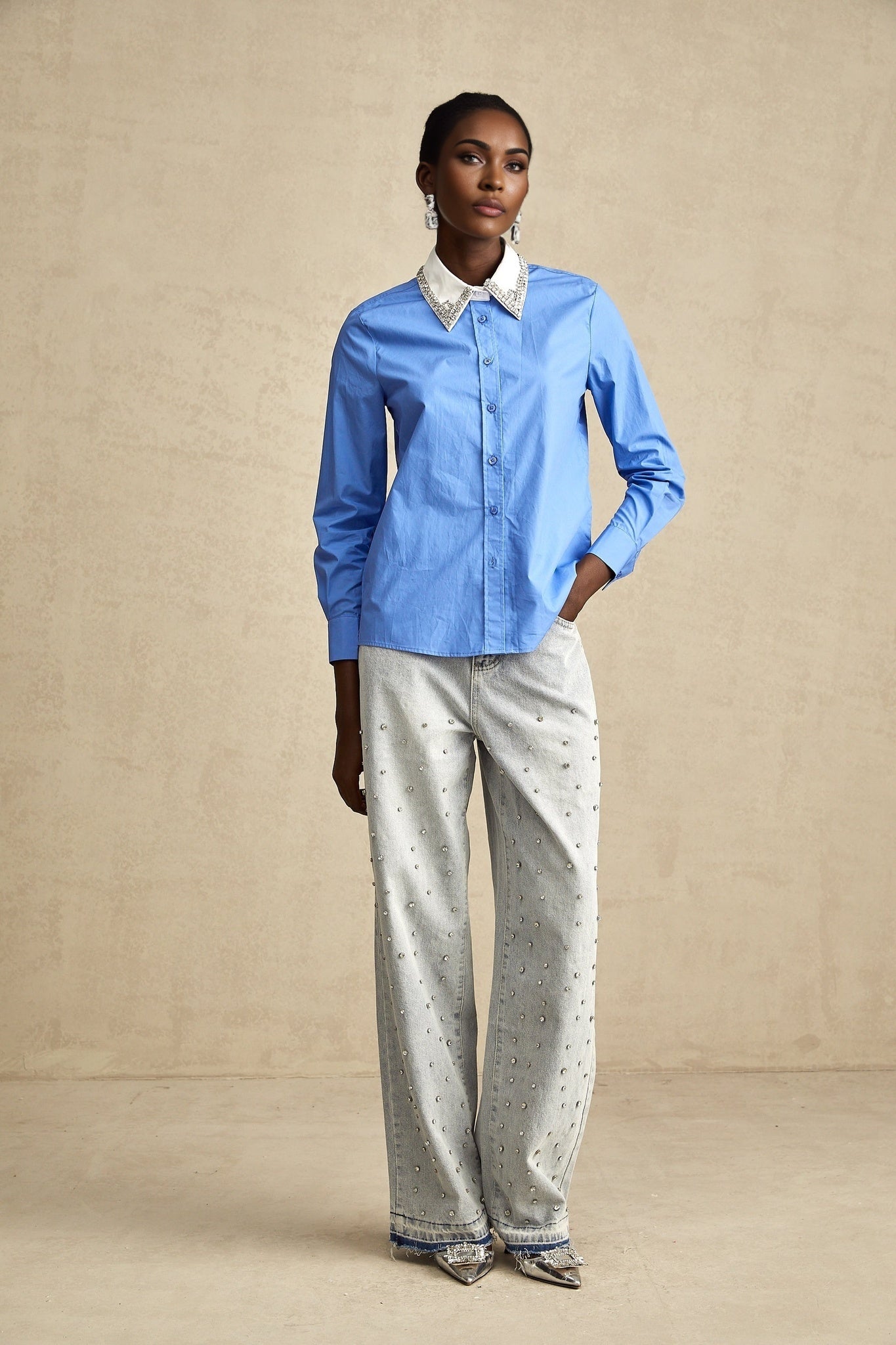 A blue shirt with color blocked sections and rhinestone embellishments called Émilie
