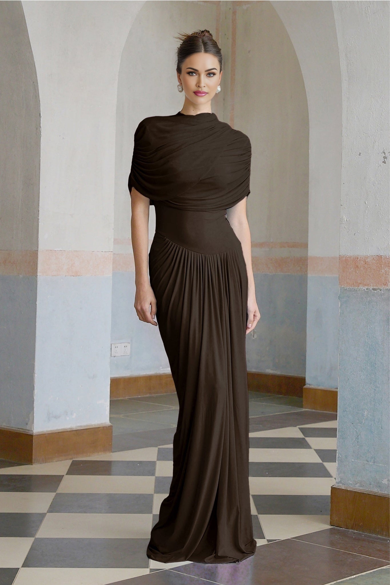 A brown asymmetric maxi dress with pleated details and an uneven hemline worn by a female model