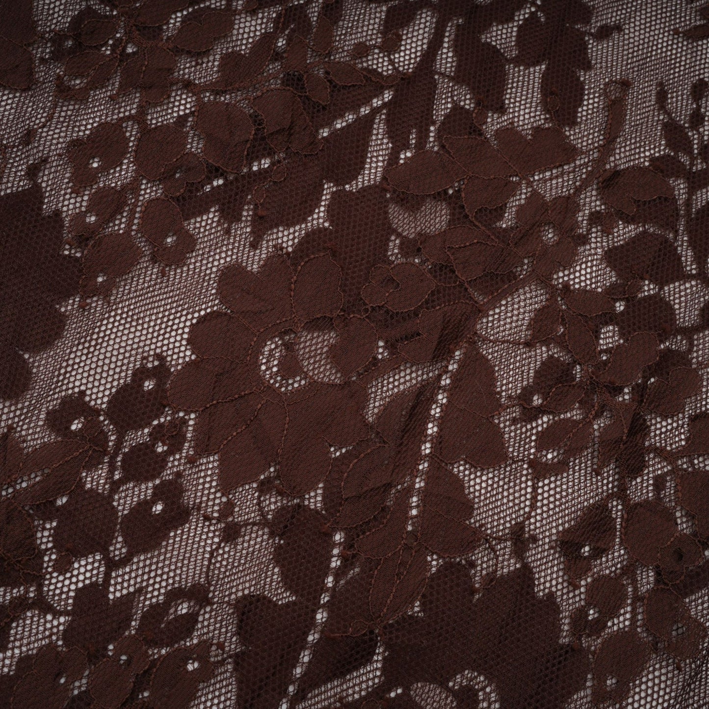 A brown flared midi dress made of chantilly lace named Sylvie hanging on a hanger against a plain background