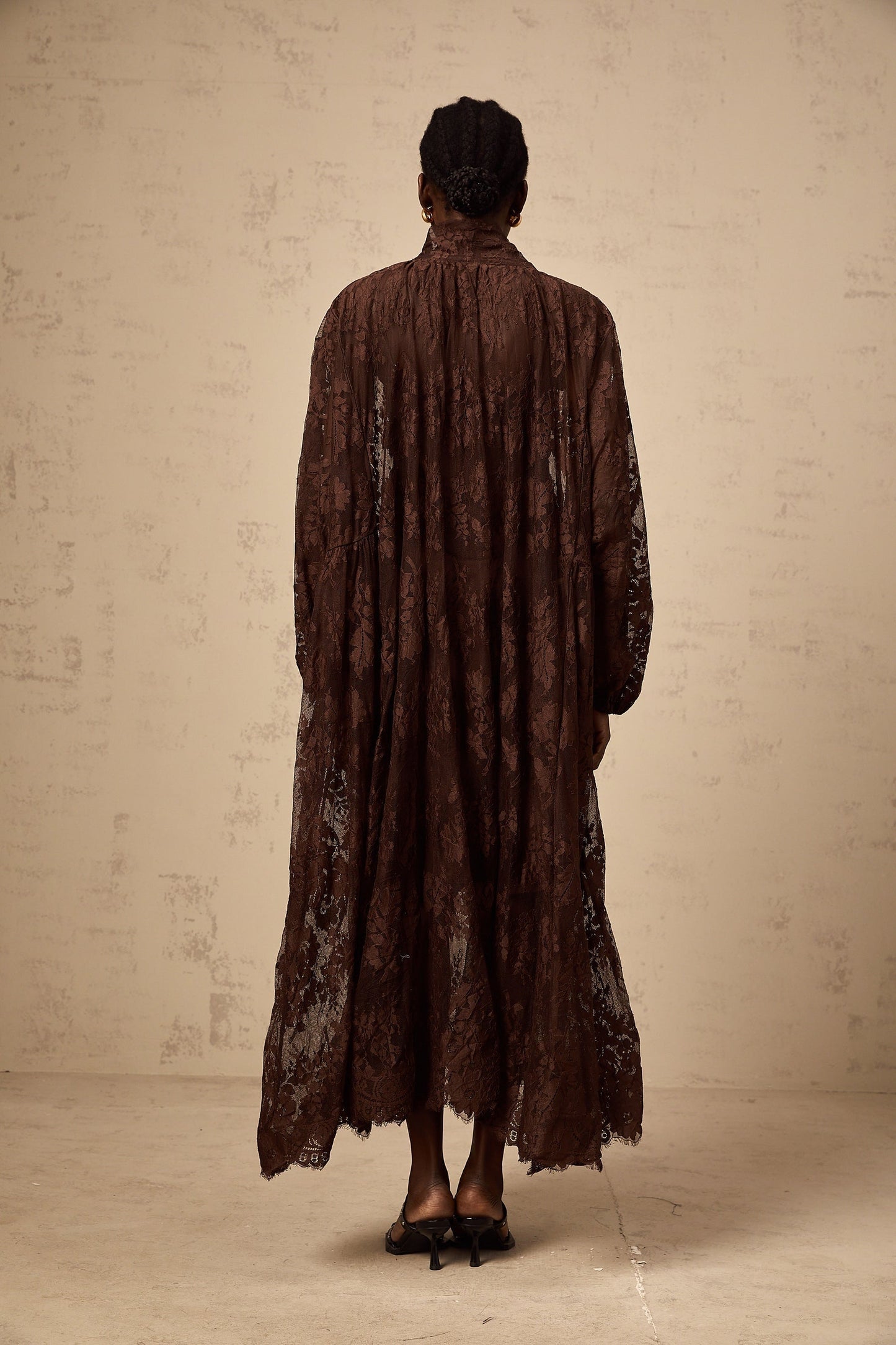 A brown flared midi dress made of chantilly lace named Sylvie with a fitted bodice and flowing skirt