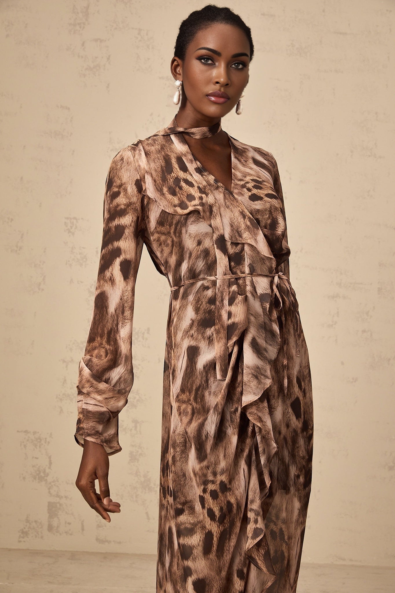 A brown midi dress with ruffled details and a leopard print pattern throughout