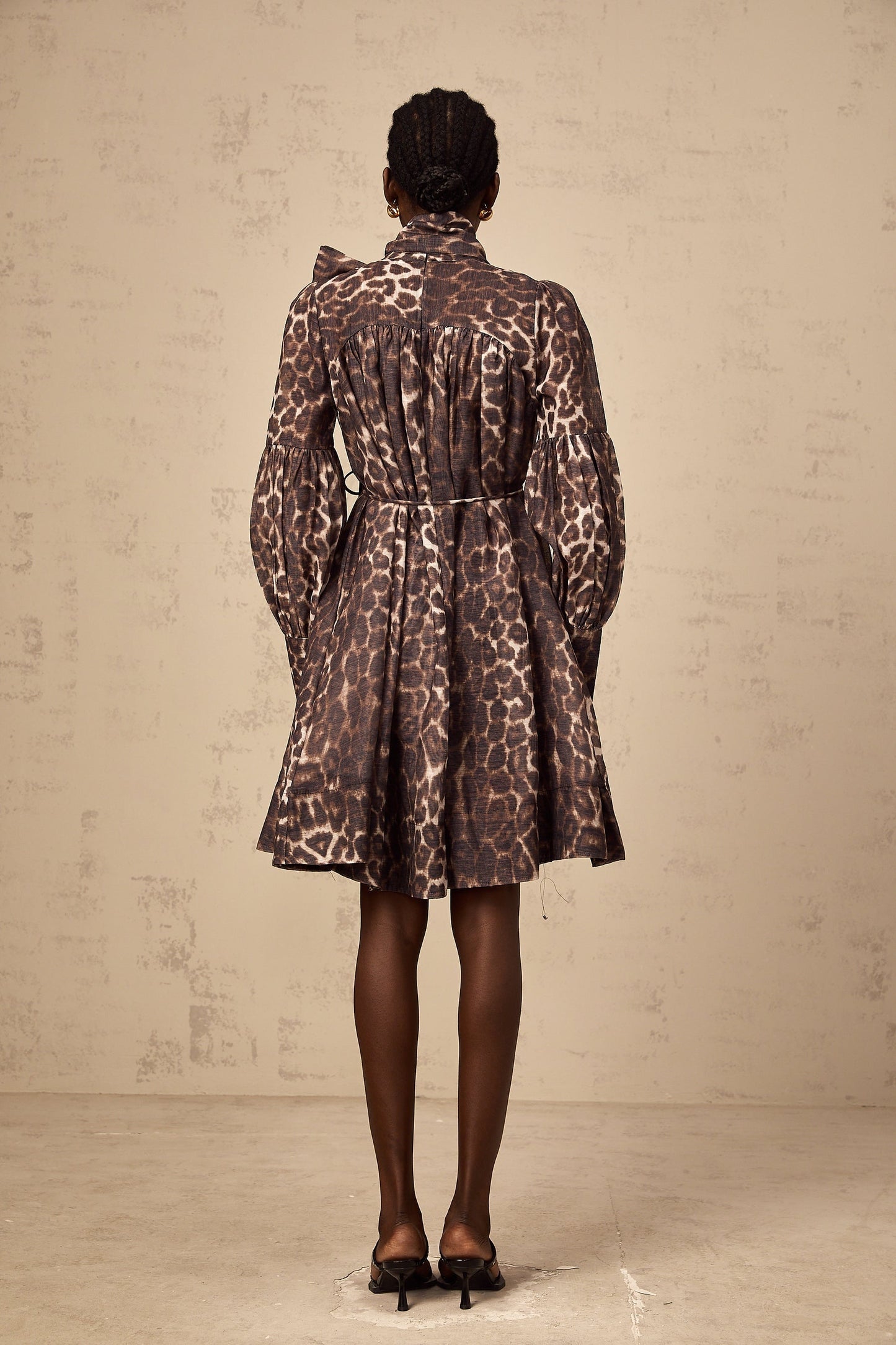 A brown mini dress with leopard print featuring a large bowknot detail and a xylene inspired design
