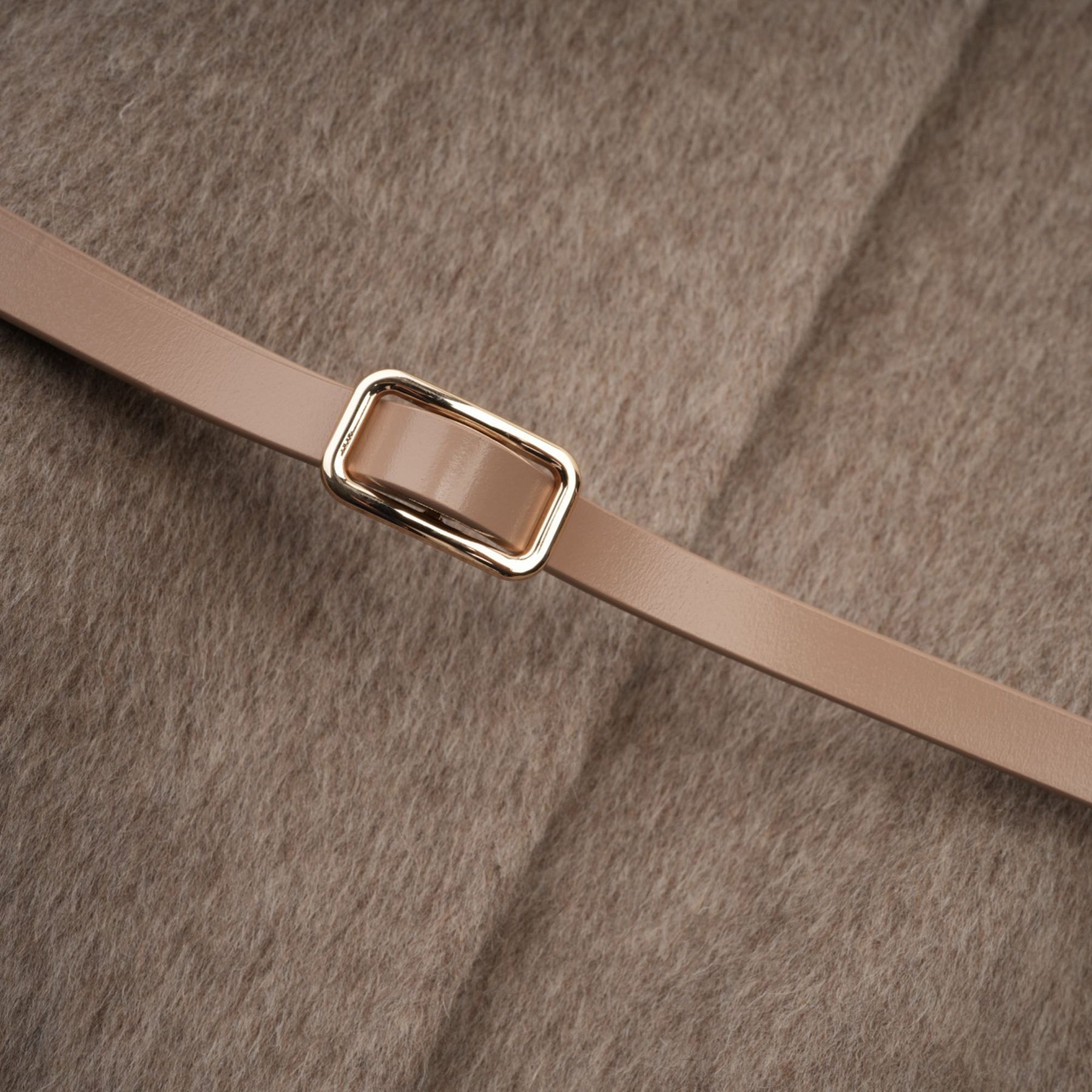 A brown wool cape coat with fur trim and a belt cinched at the waist