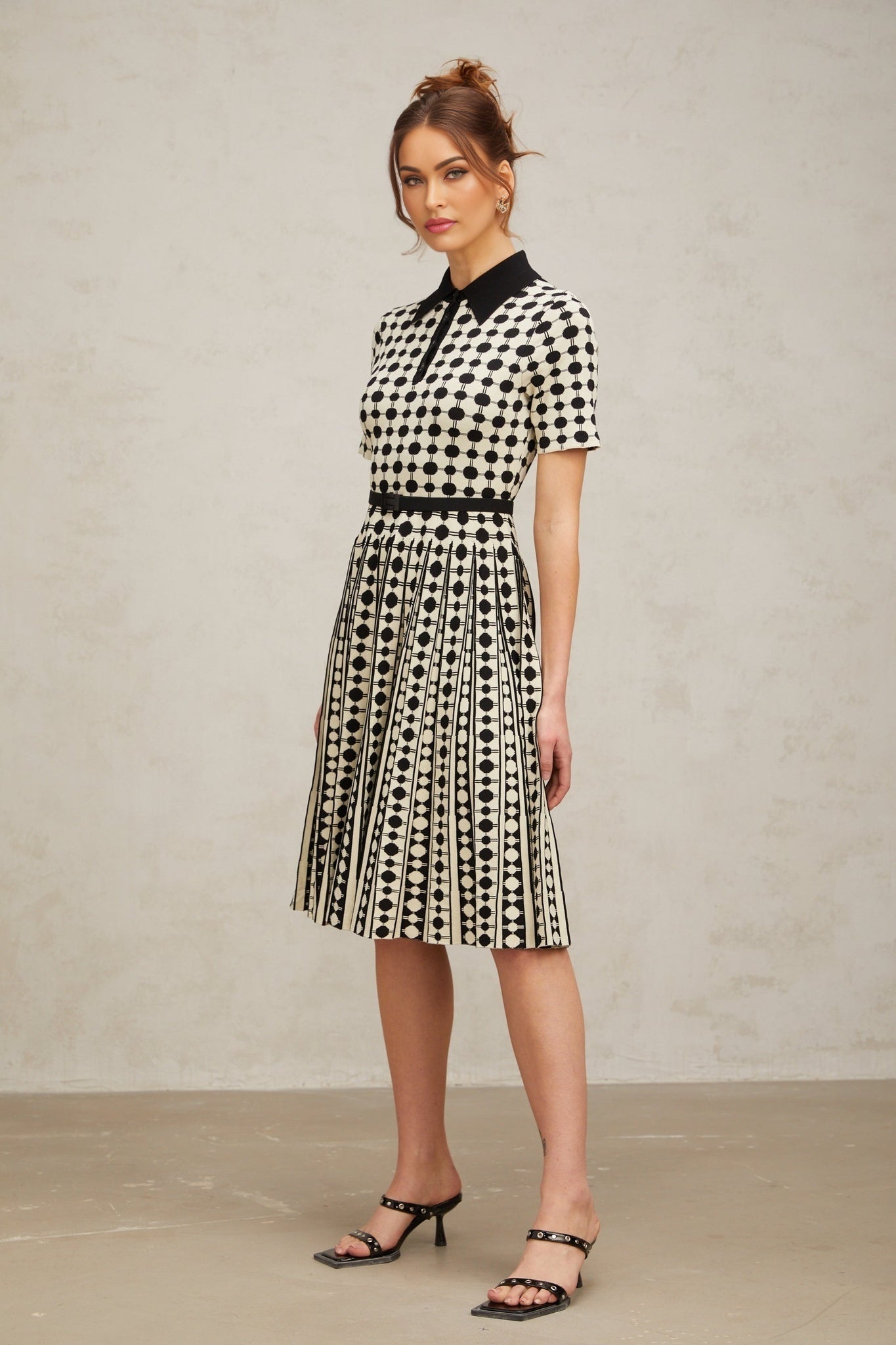 A colorful knit midi dress with polka dot pattern and color block design featuring different sections in contrasting colors