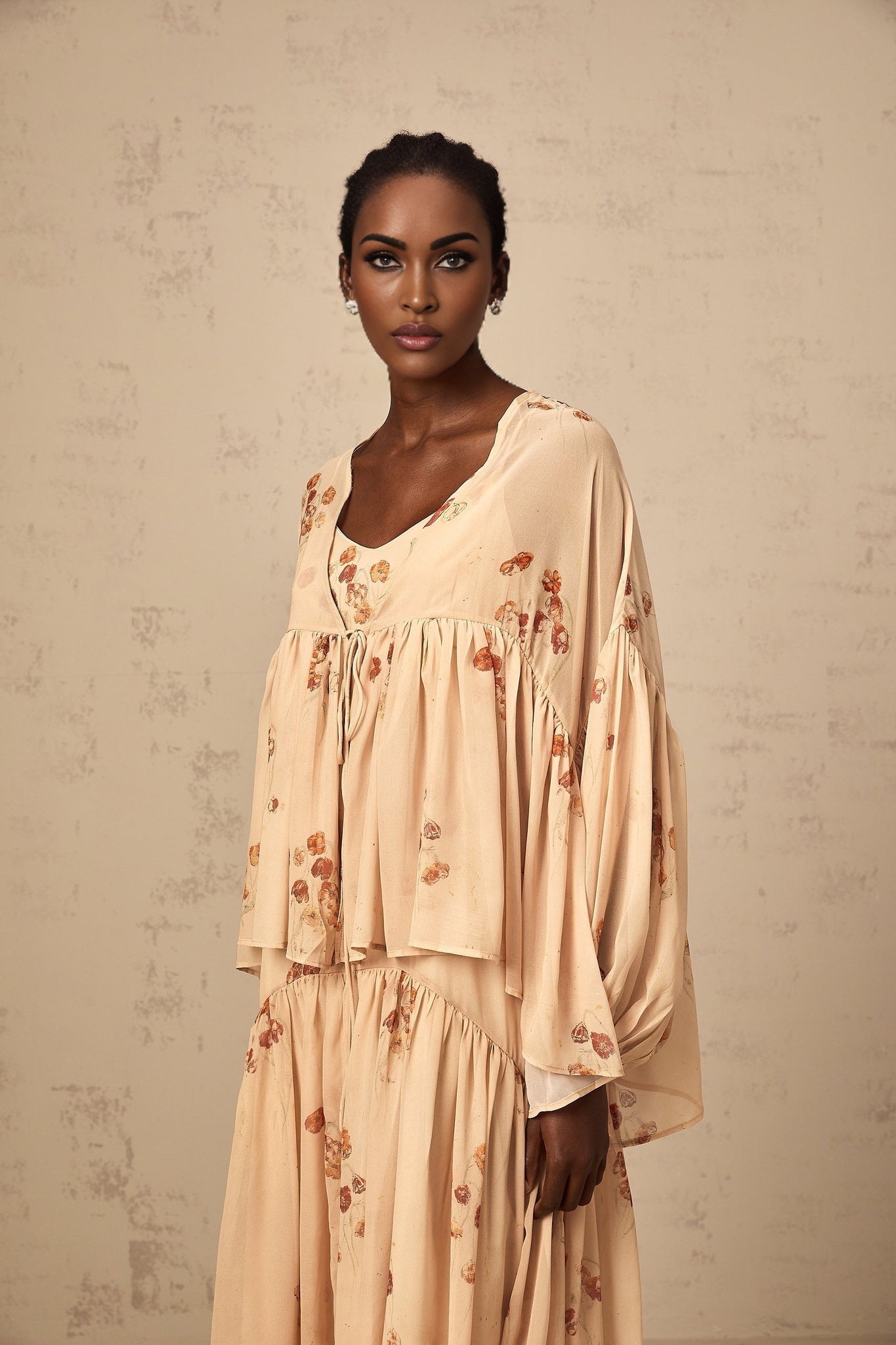 A coralpink floral print matching set featuring a pleated blouse and dress in the Maïa style