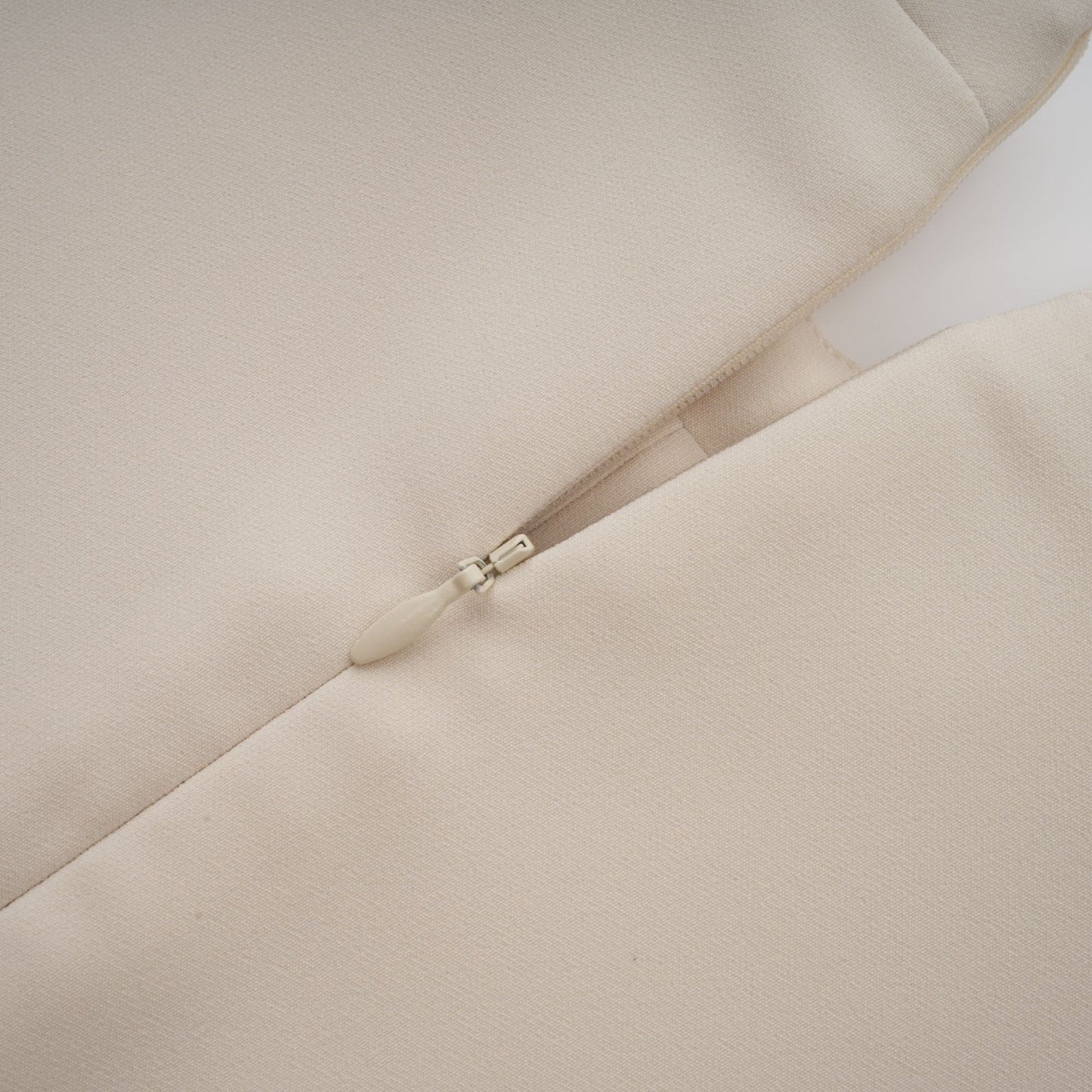 A creamwhite fitted mini dress by Chloé on a plain background showcasing its sleek silhouette and elegant design