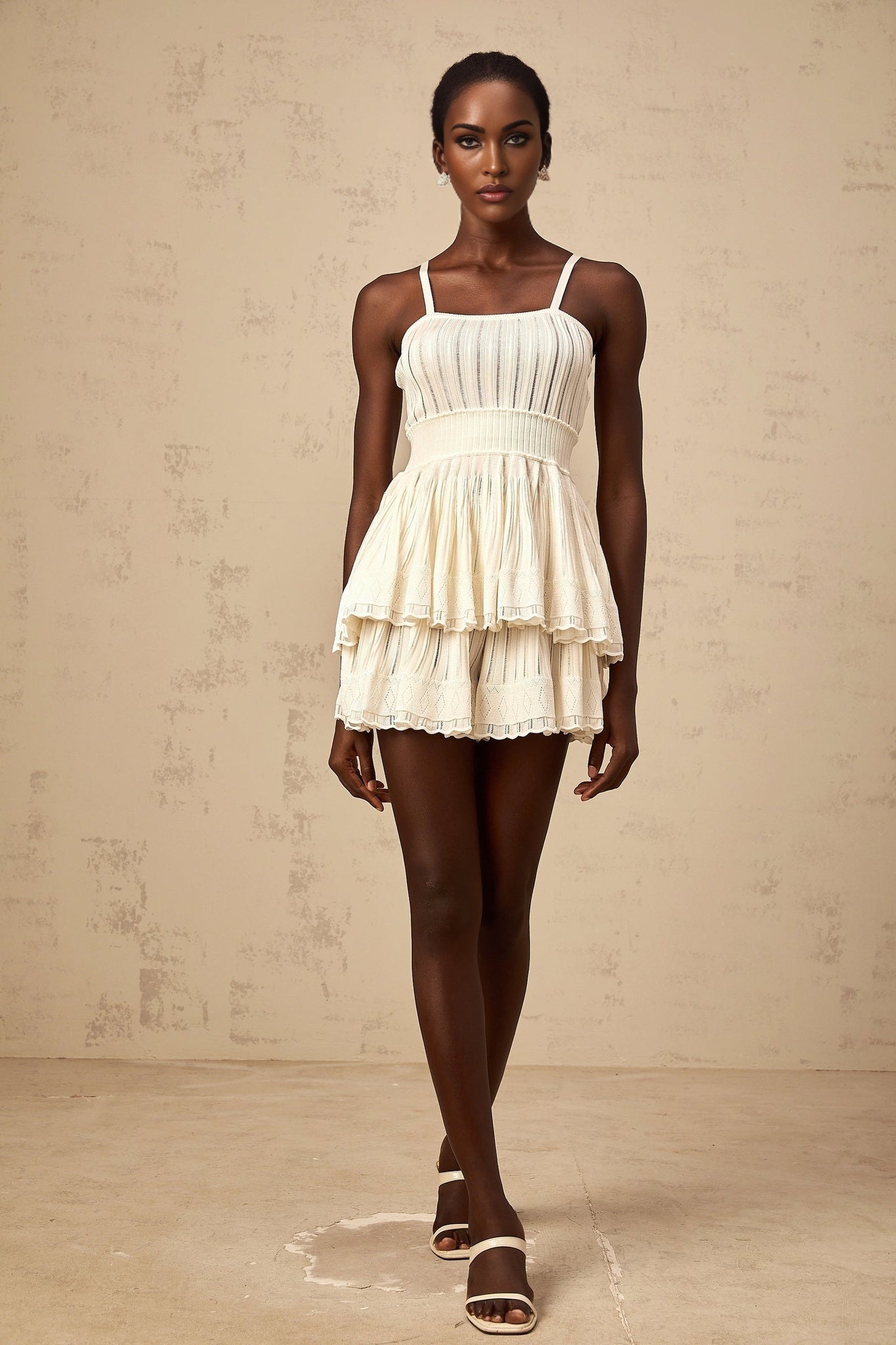 A creamwhite matching set featuring a shirred crochetknit top paired with wideleg culottes both in a delicate knit texture