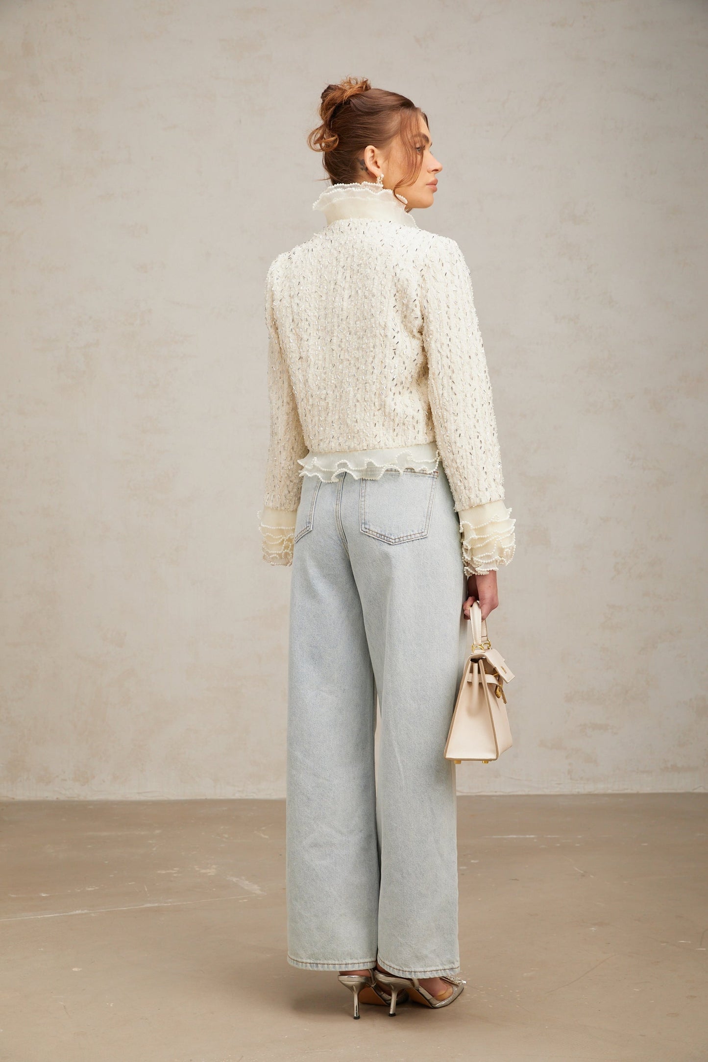 A cropped white jacket with beaded embellishments and ruffle details named Blanche