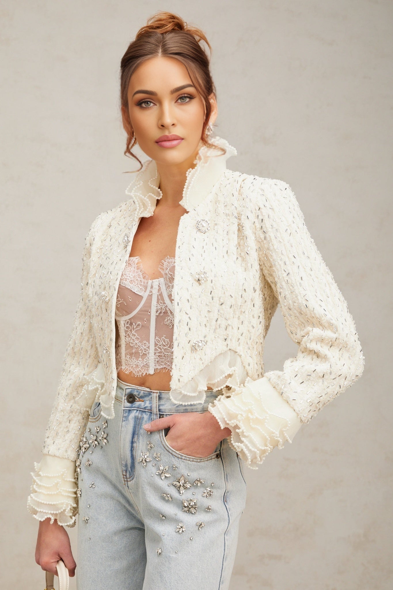 A cropped white jacket with beaded embellishments and ruffled details named Blanche