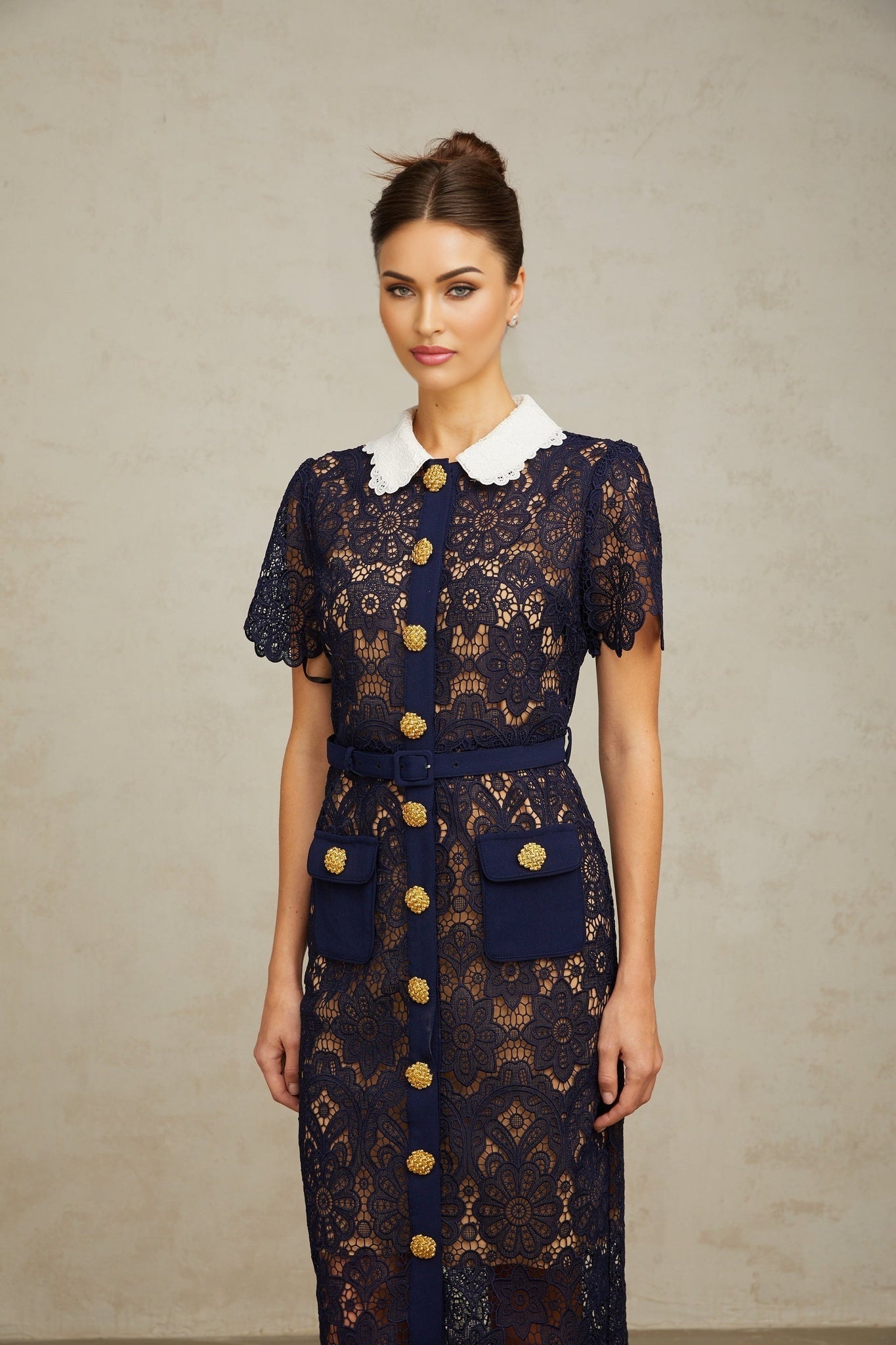 A dark blue midi dress with a floral crochet lace pattern covering the entire garment