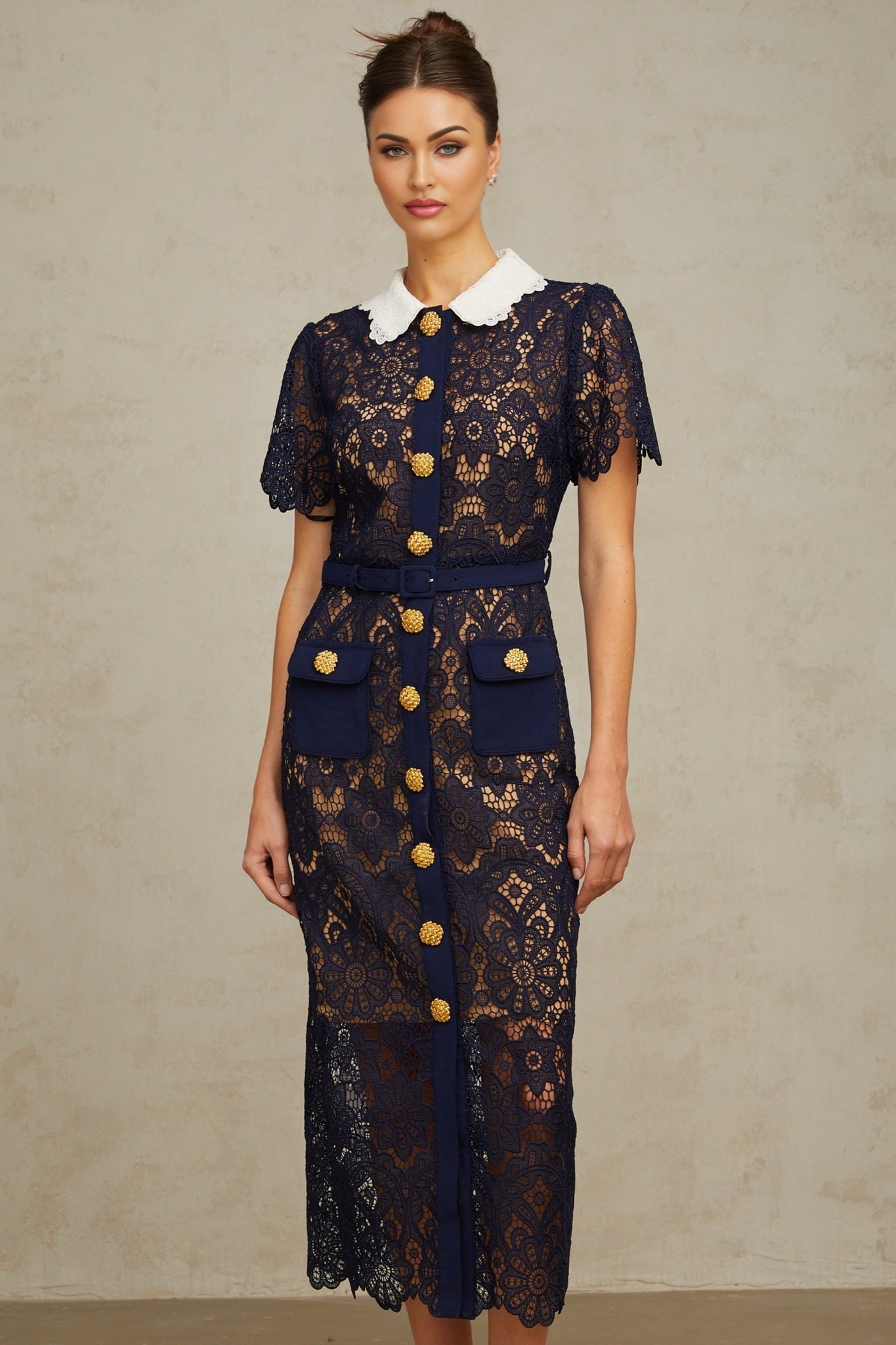 A dark blue midi dress with a floral crochet lace pattern covering the entire garment
