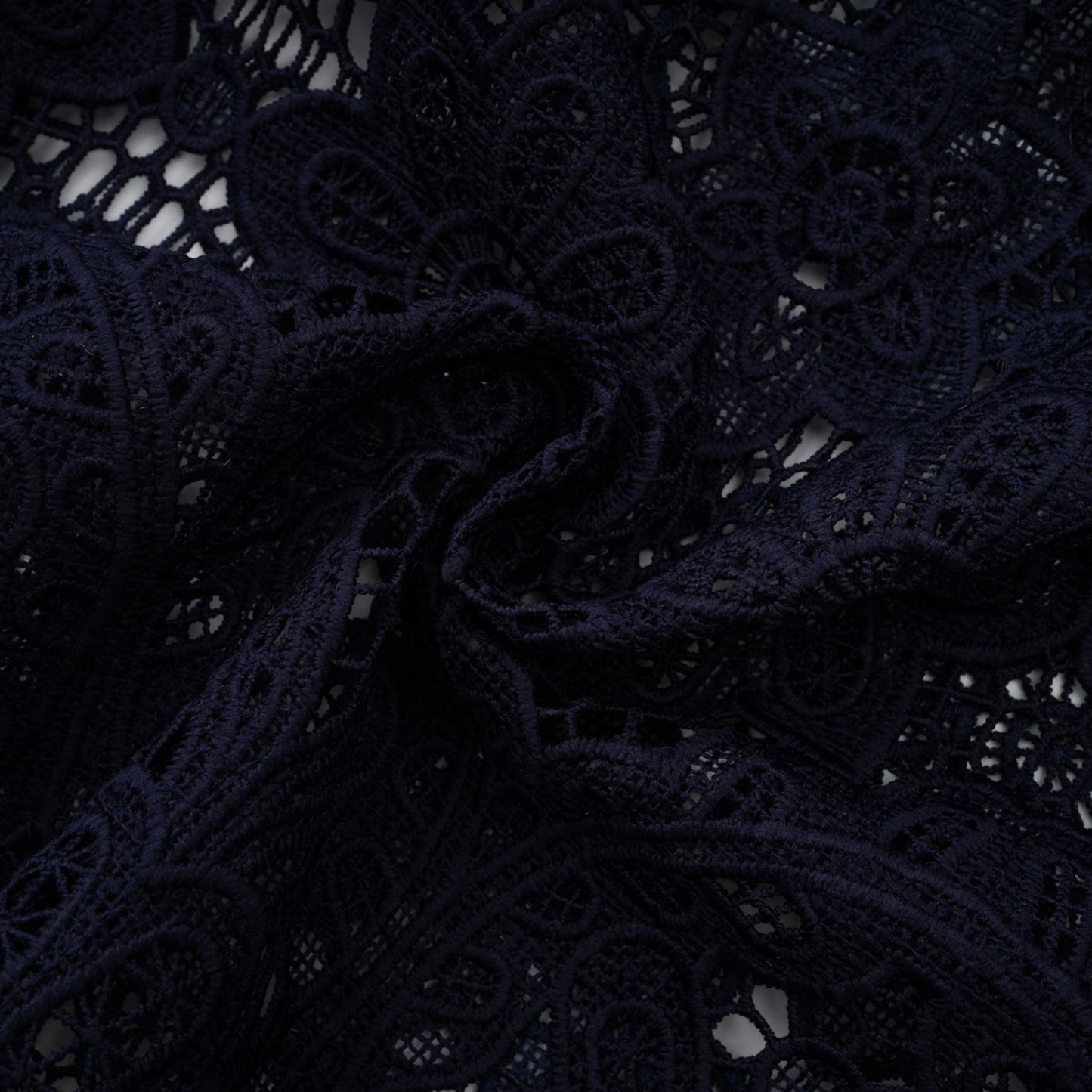A dark blue midi dress with floral crochet lace pattern and a fitted silhouette