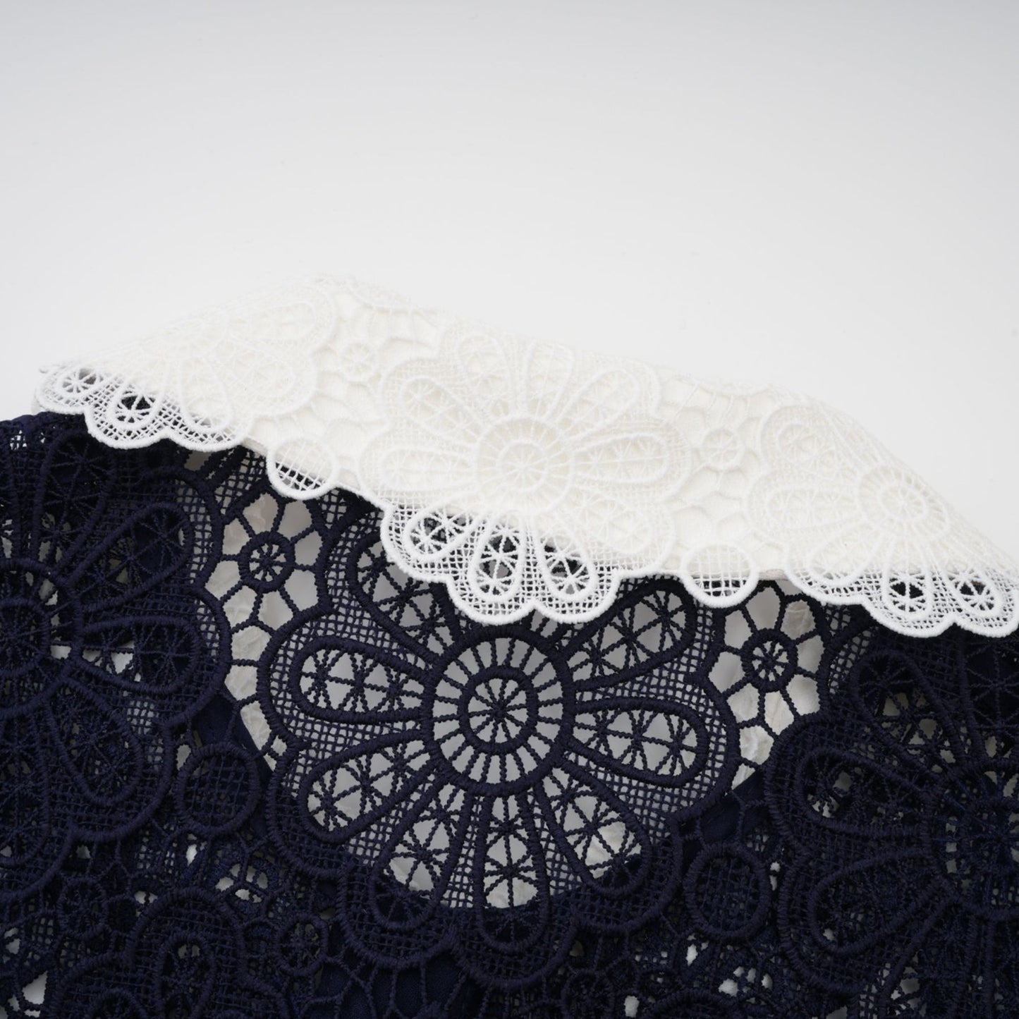 A dark blue midi dress with floral crochet lace pattern and delicate details