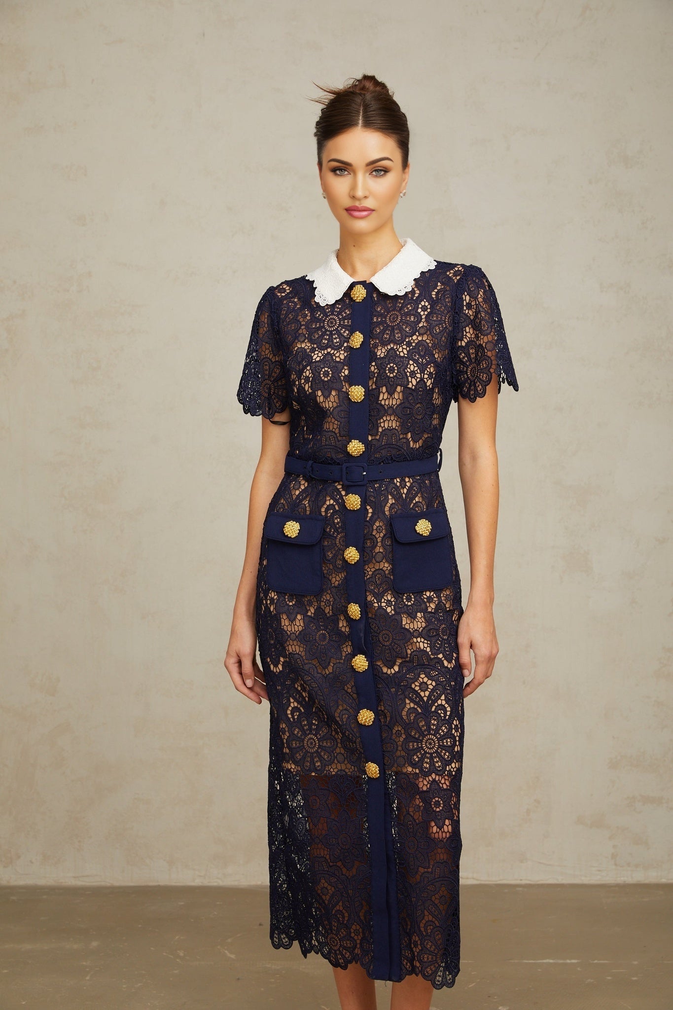 A dark blue midi dress with floral crochet lace pattern and intricate detailing