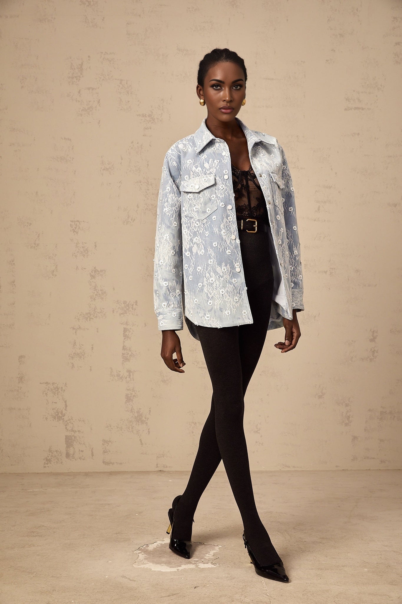 A denim jacket in light blue with shimmering blue sequins and floral applique details