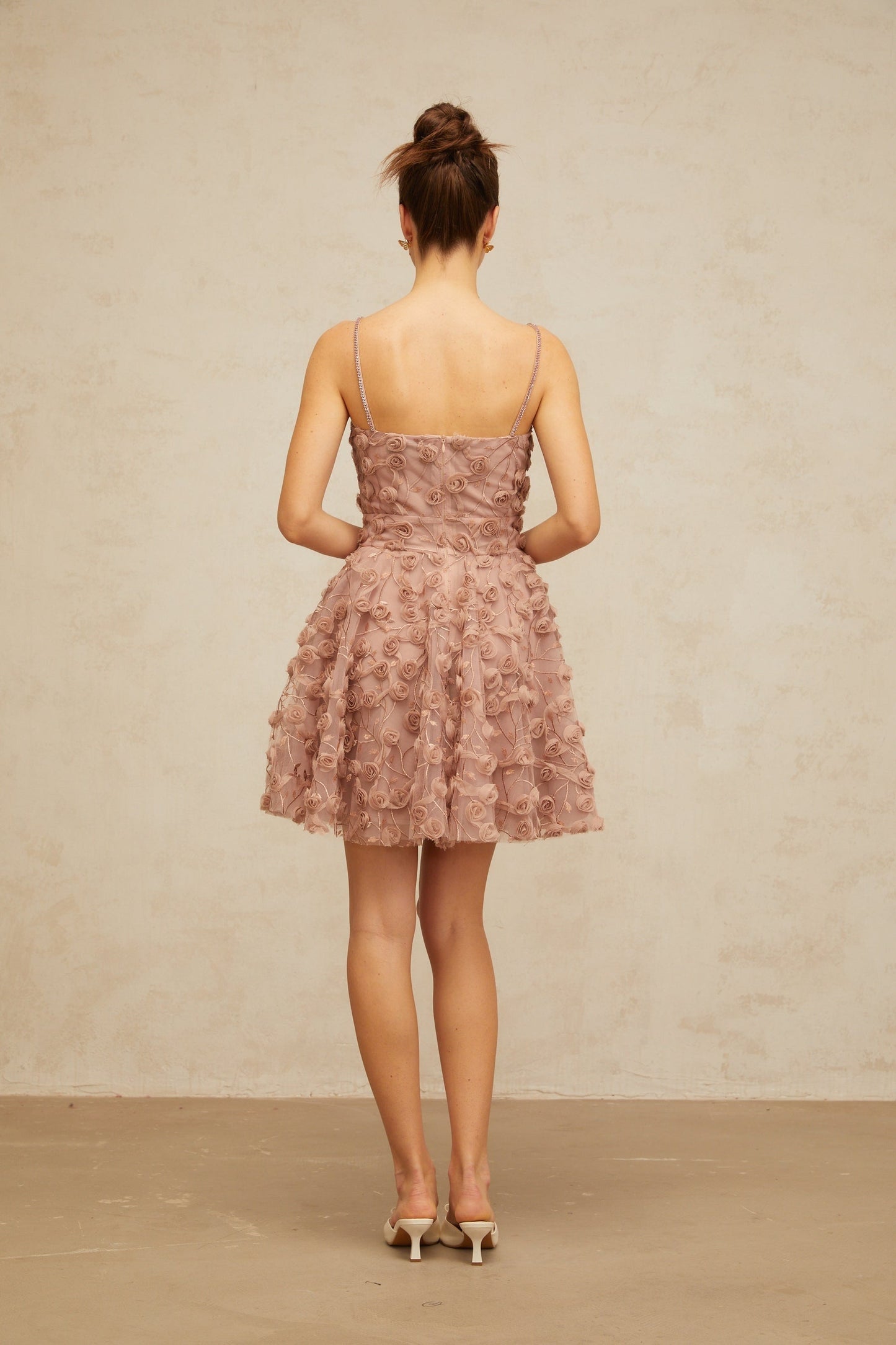 A dusty pink mini dress with rose appliques and a flounced skirt