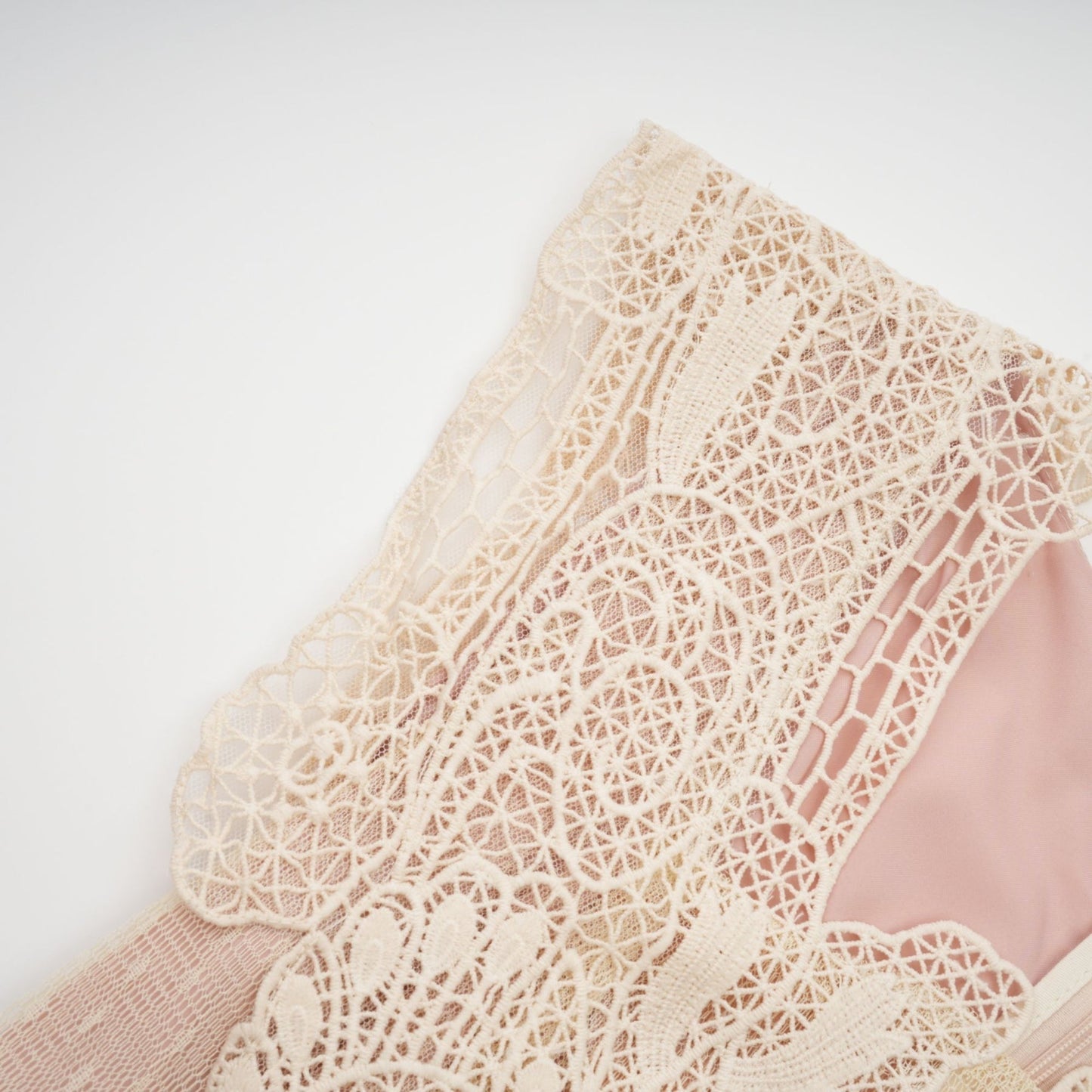 A feminine midi dress in neutral tones featuring floral lace paneling and sheer tulle fabric with a delicate Celeste design