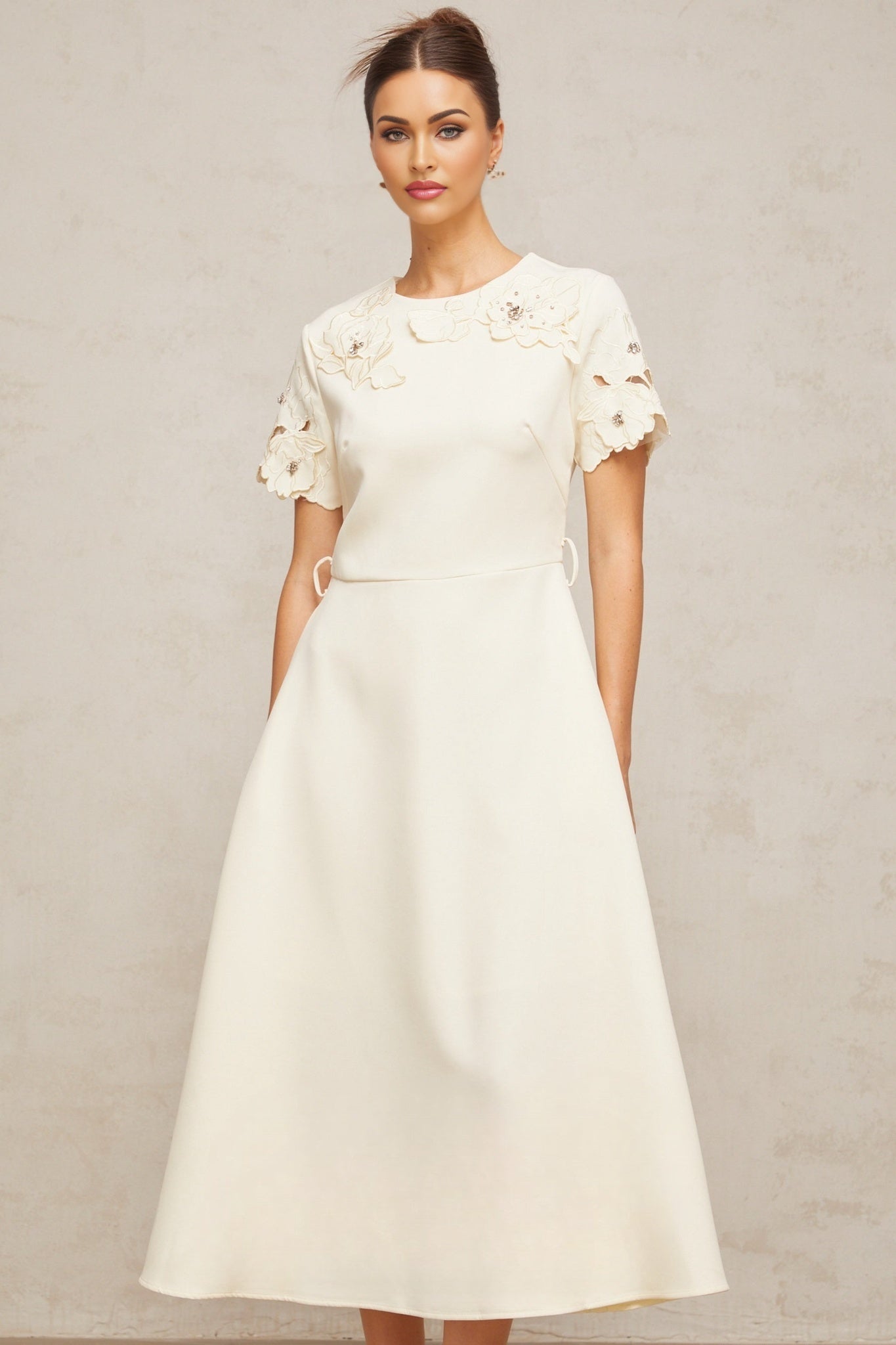 A flared midi dress in neutral tones featuring orange floral appliqués on the fabric