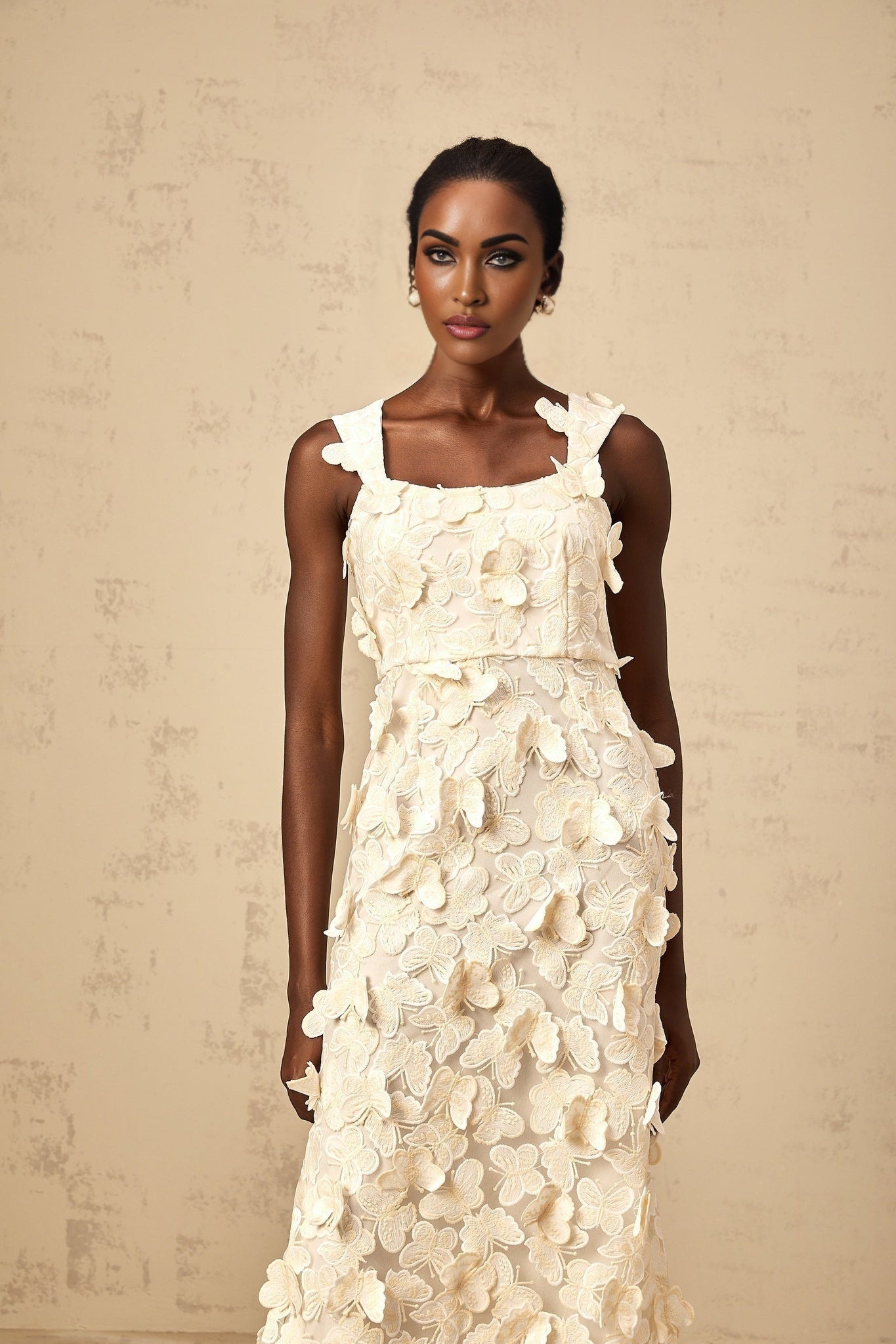 A flared midi dress with butterfly appliques inspired by the Narcisse design featuring a fitted bodice and flowing skirt in a feminine silhouette