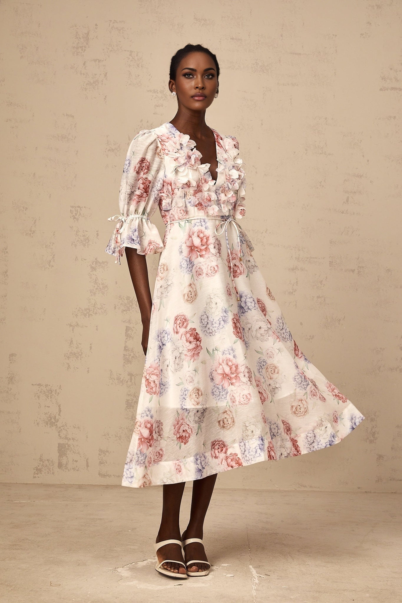 A floral midi dress with a 3d petal print design featuring a vibrant pattern on a flowing silhouette