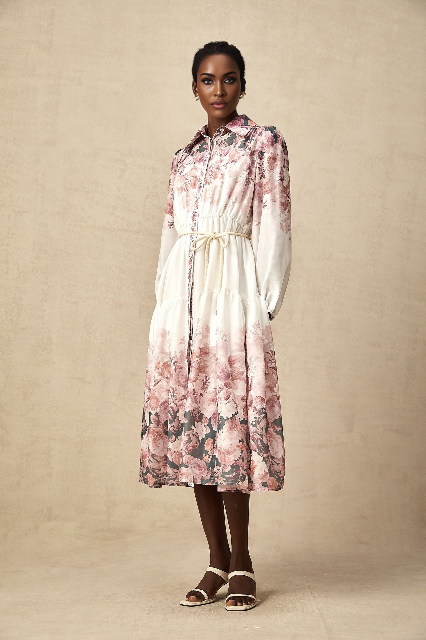 A floral patterned midi dress with lantern sleeves in a style called Carina The dress features a colorful floral print on a light background and has voluminous sleeves that taper at the wrist