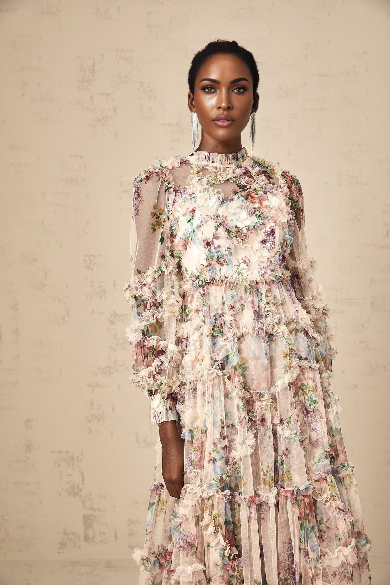 A floral patterned midi dress with ruffled details and a tulle overlay featuring a feminine silhouette and delicate floral print throughout