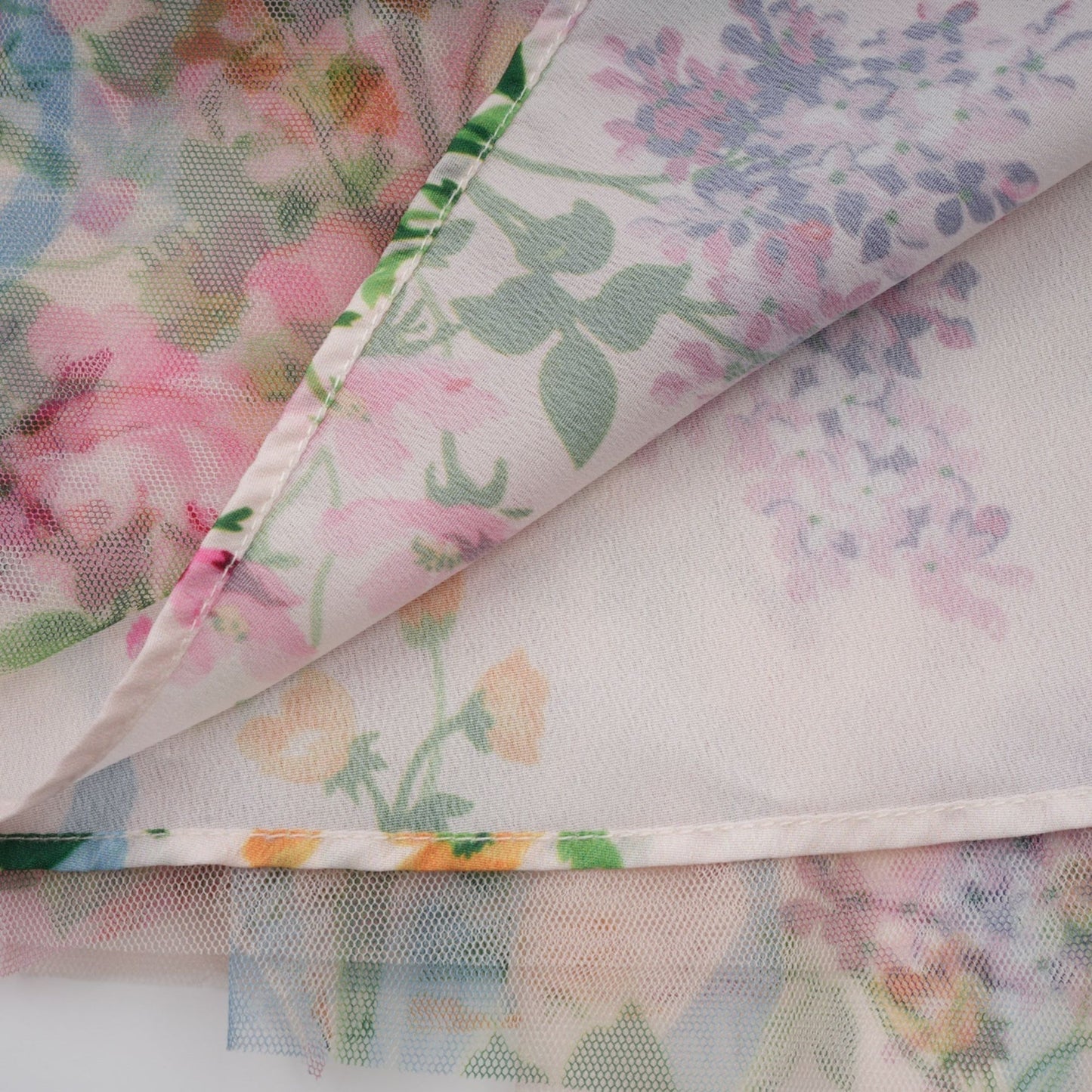 A floral patterned midi dress with ruffled tulle details and a feminine silhouette