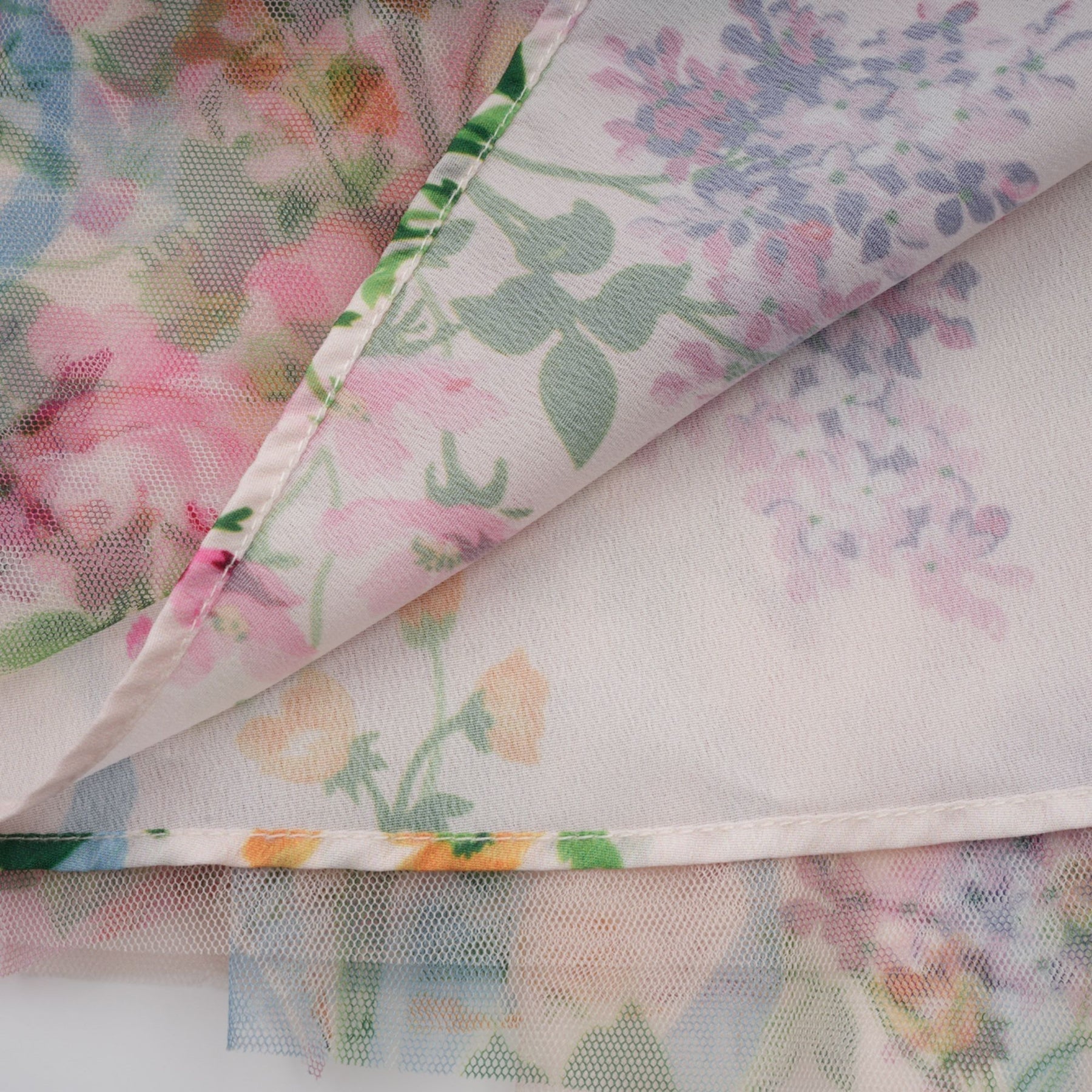 A floral patterned midi dress with ruffled tulle details and a feminine silhouette