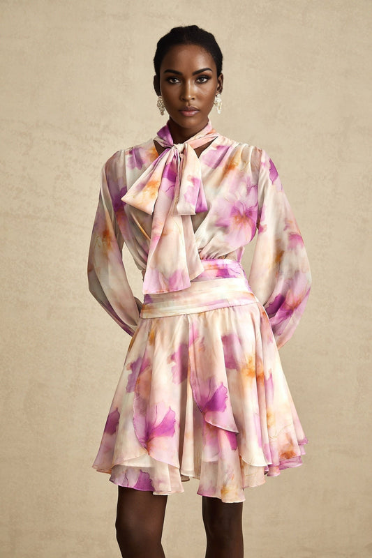 A floral patterned mini dress with a V neckline featuring the Maelys design in vibrant colors on a light background