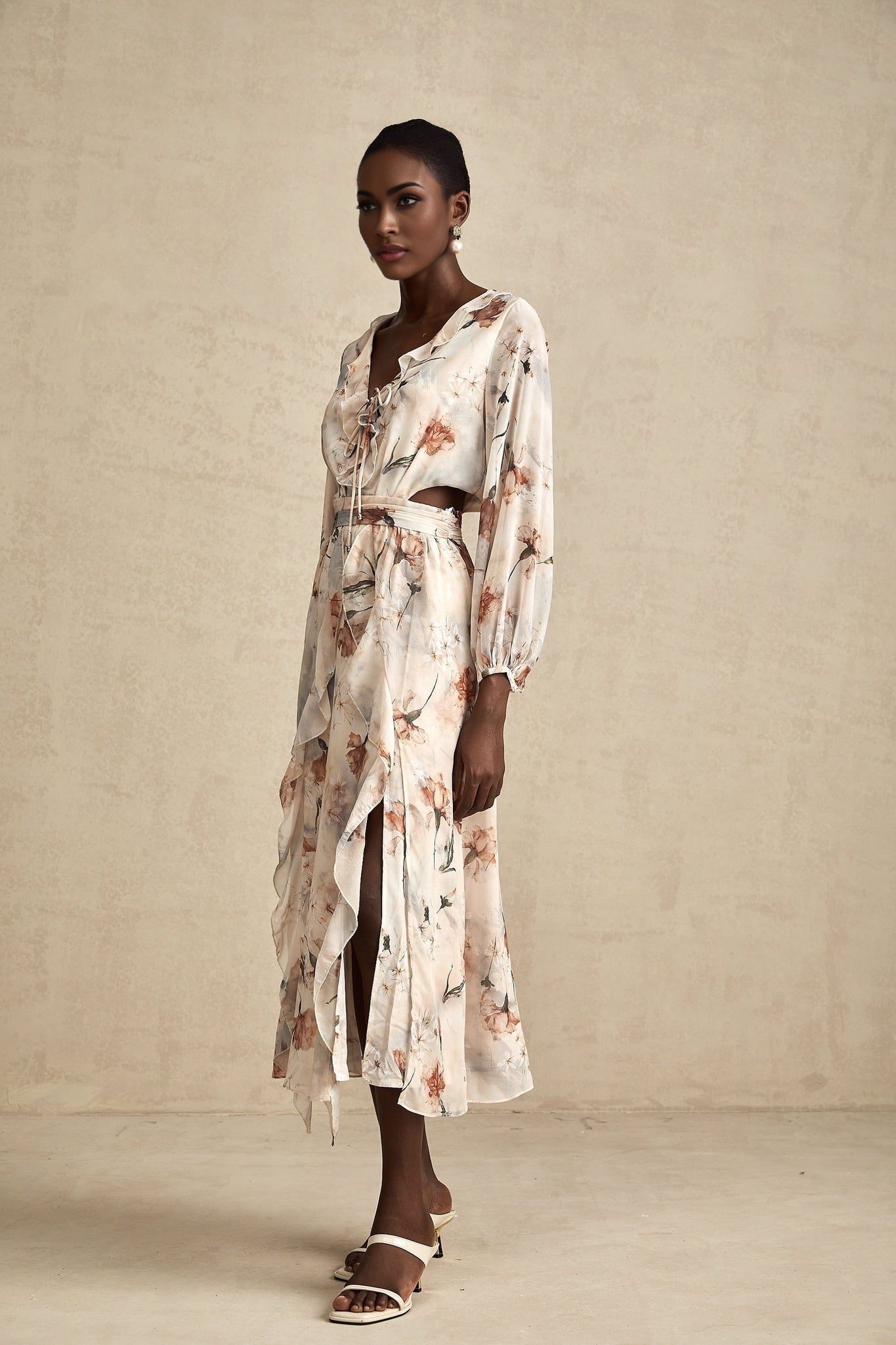 A floral print midi dress with an open waist design named Bérengère featuring a colorful pattern on a light background and a flowing silhouette