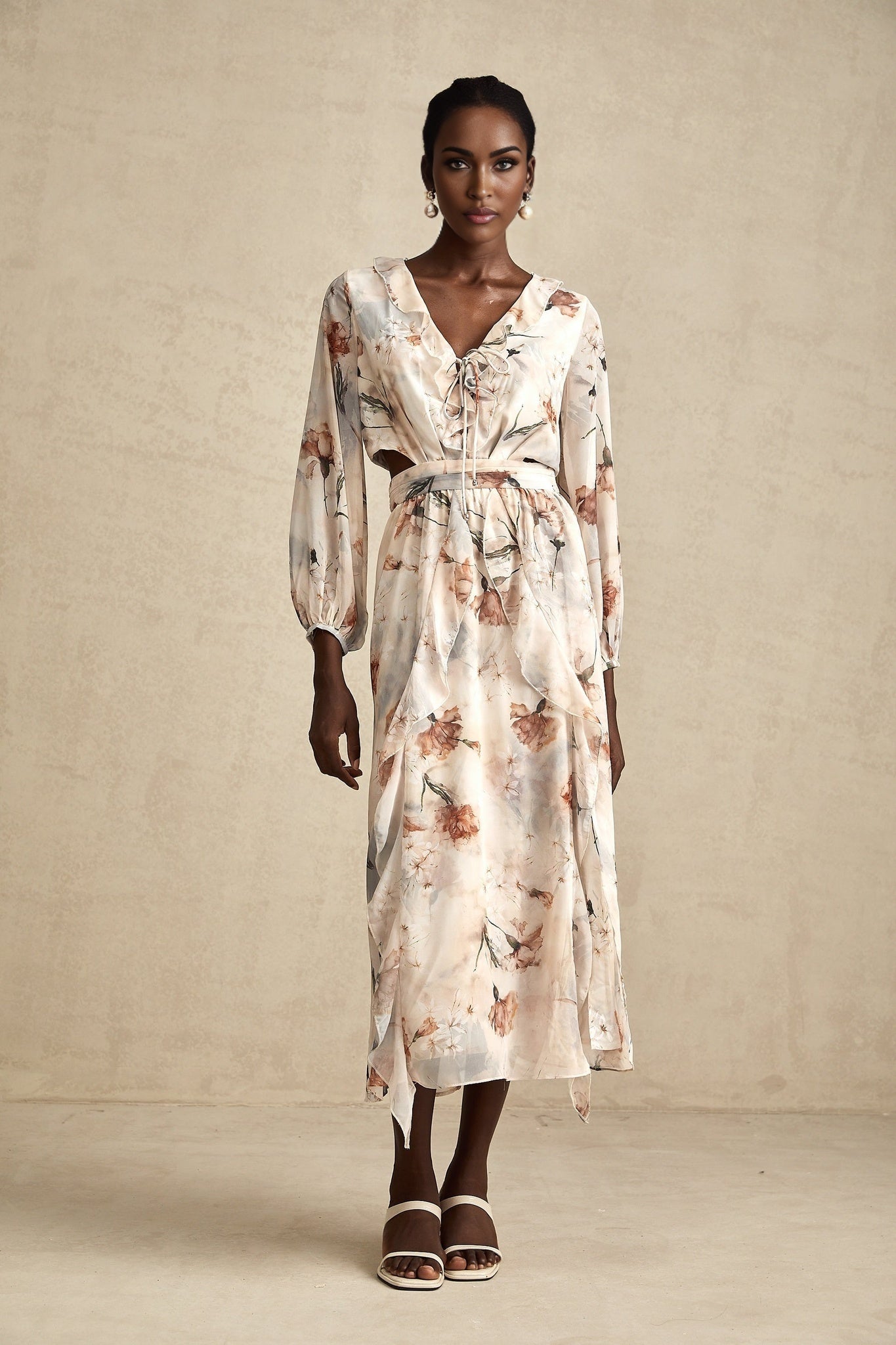 A floral print midi dress with an open waist design named Berengere featuring a colorful pattern on a light background