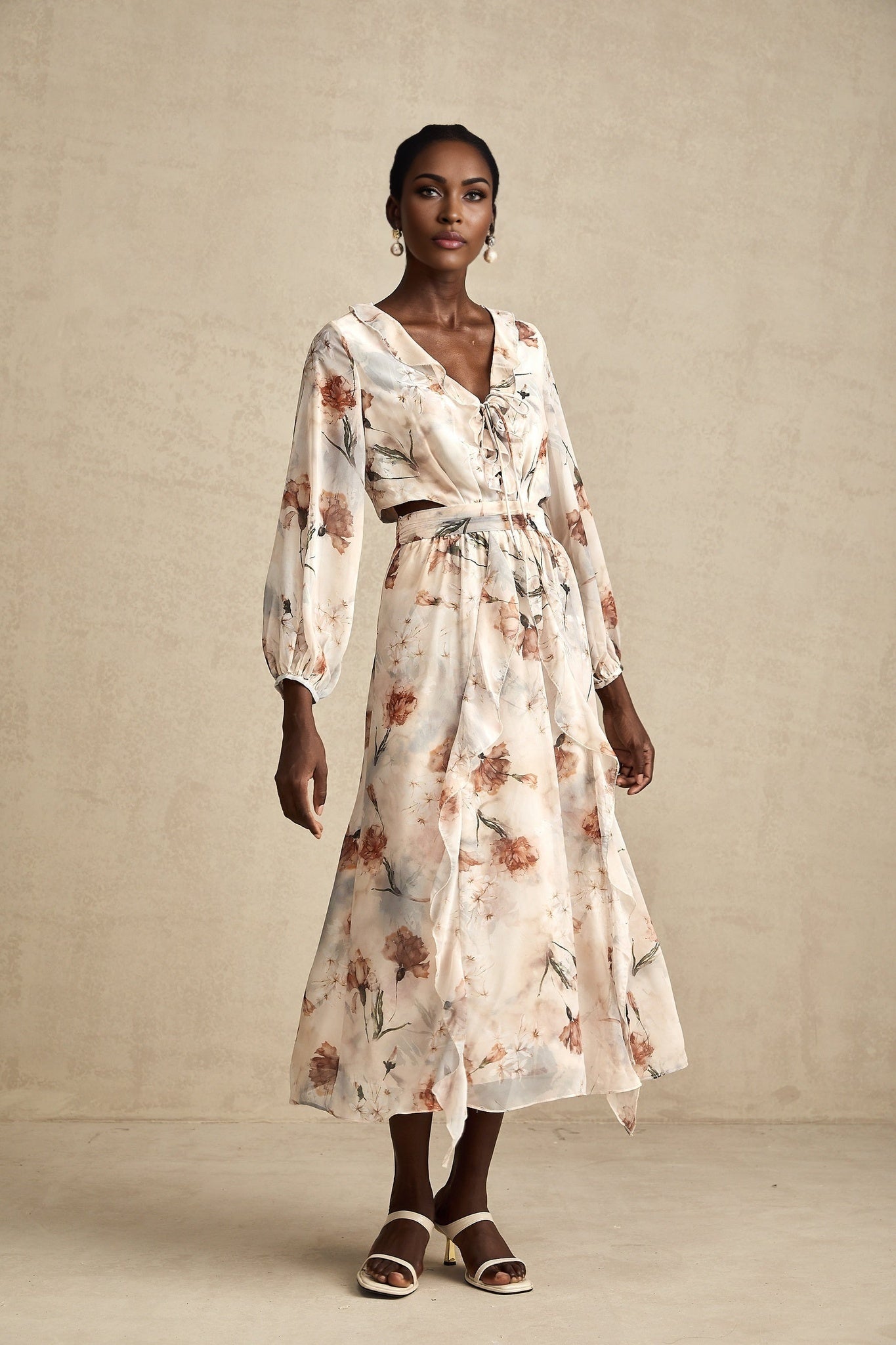 A floral print midi dress with an open waist design named Berengere featuring a vibrant pattern on a flowing fabric