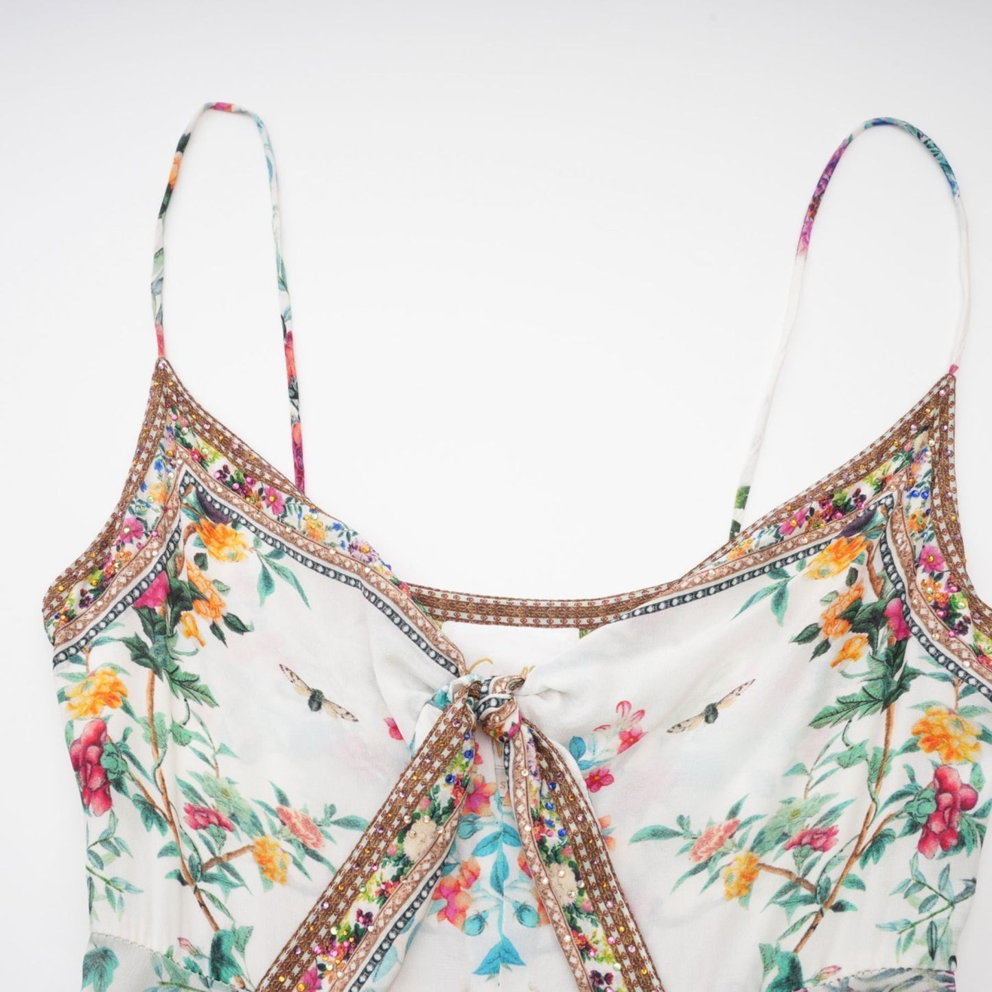A floral print midi dress with decorative details inspired by Philippine design featuring a colorful flower pattern and embellishments on a lightweight fabric suitable for warm weather
