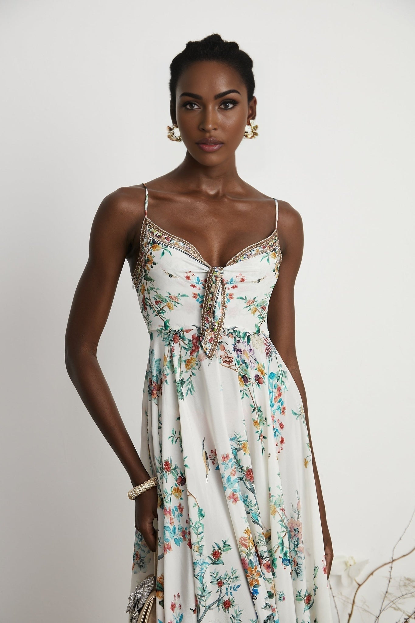 A floral print midi dress with decorative details inspired by Philippine design featuring a vibrant pattern and embellishments on a flowing silhouette