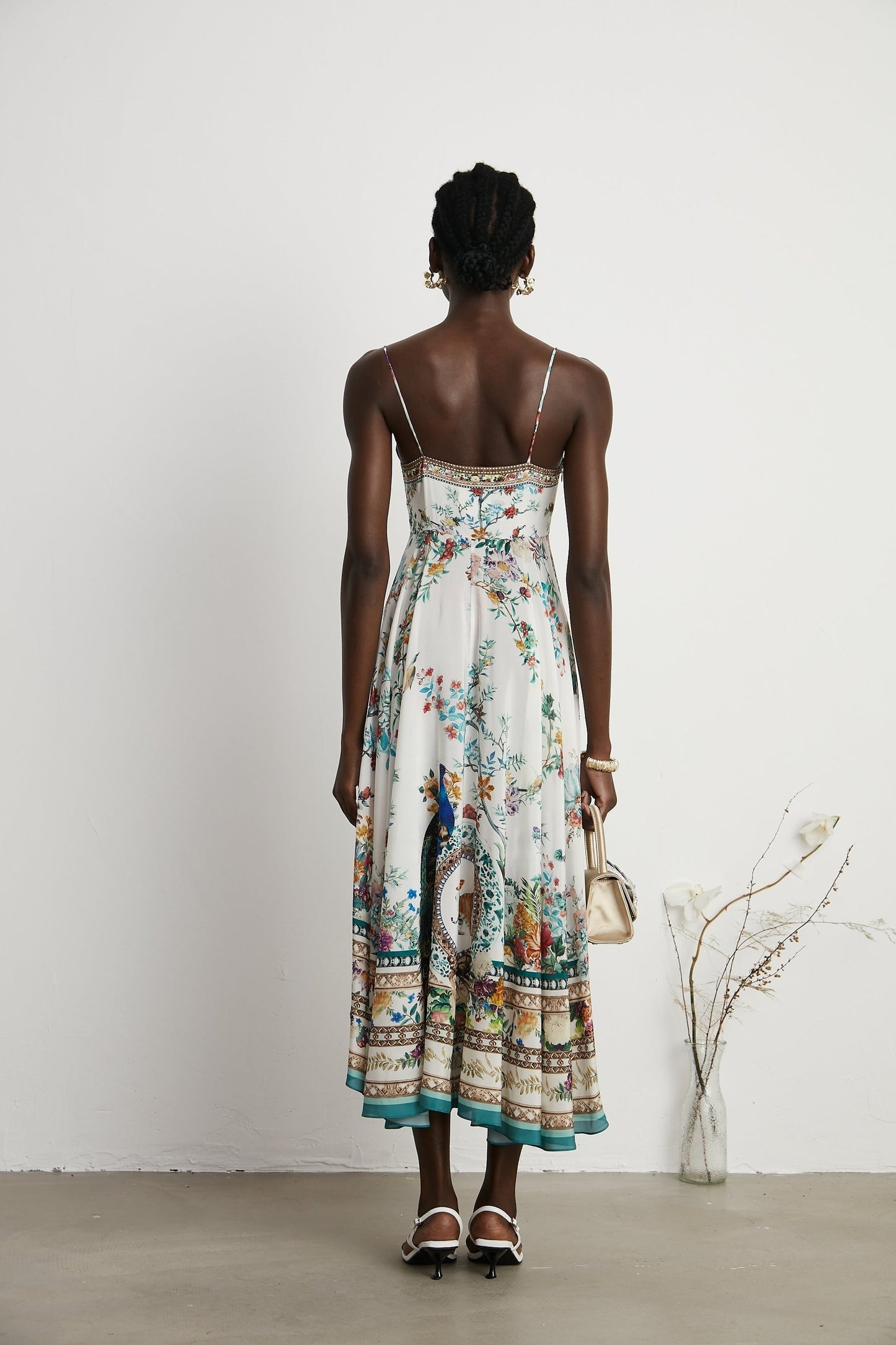 A floral print midi dress with decorative elements inspired by Philippine design featuring a colorful pattern and embellishments on a flowing silhouette