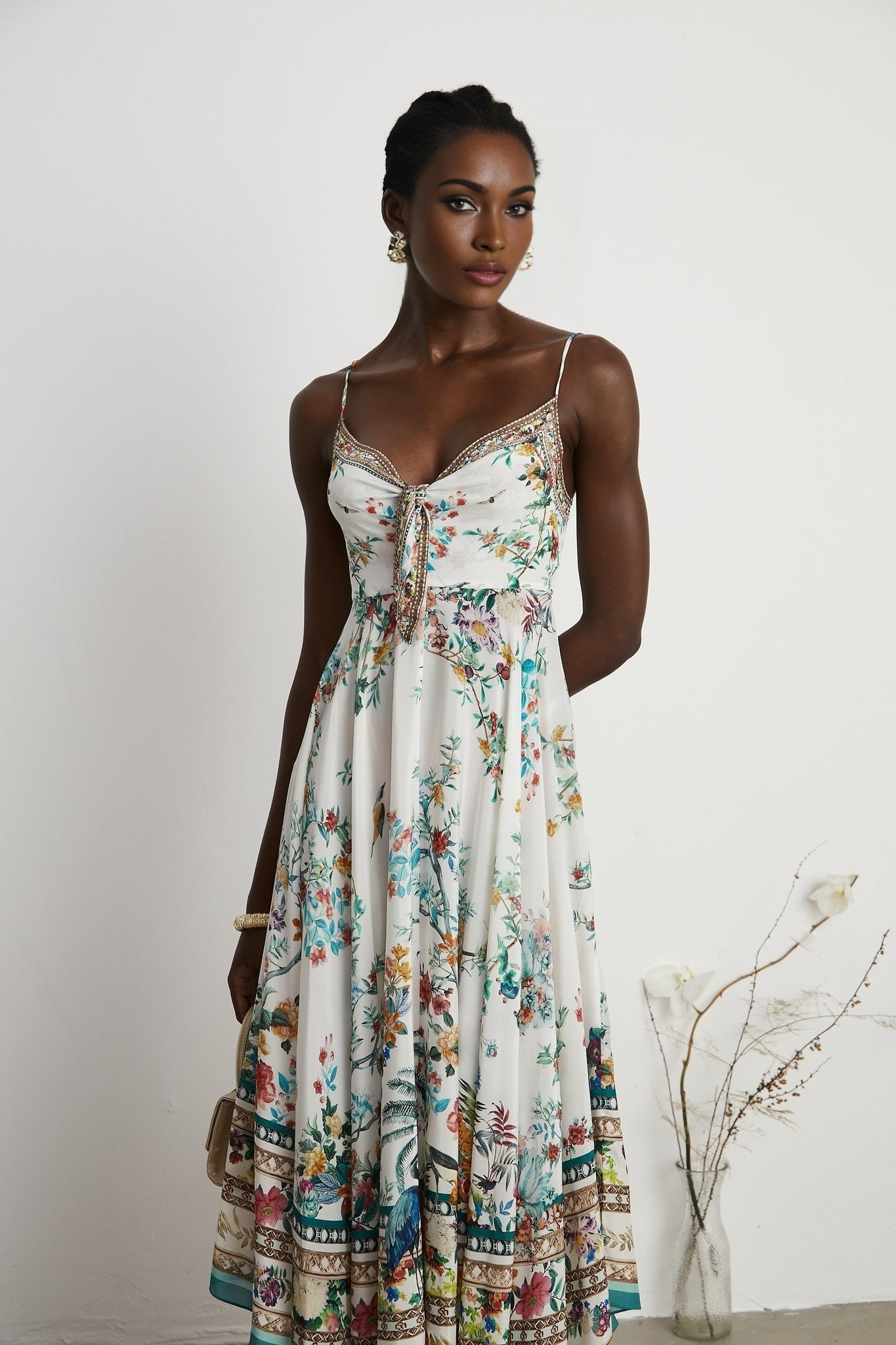 A floral print midi dress with decorative elements inspired by Philippine design featuring a colorful pattern and embellishments on a flowing silhouette