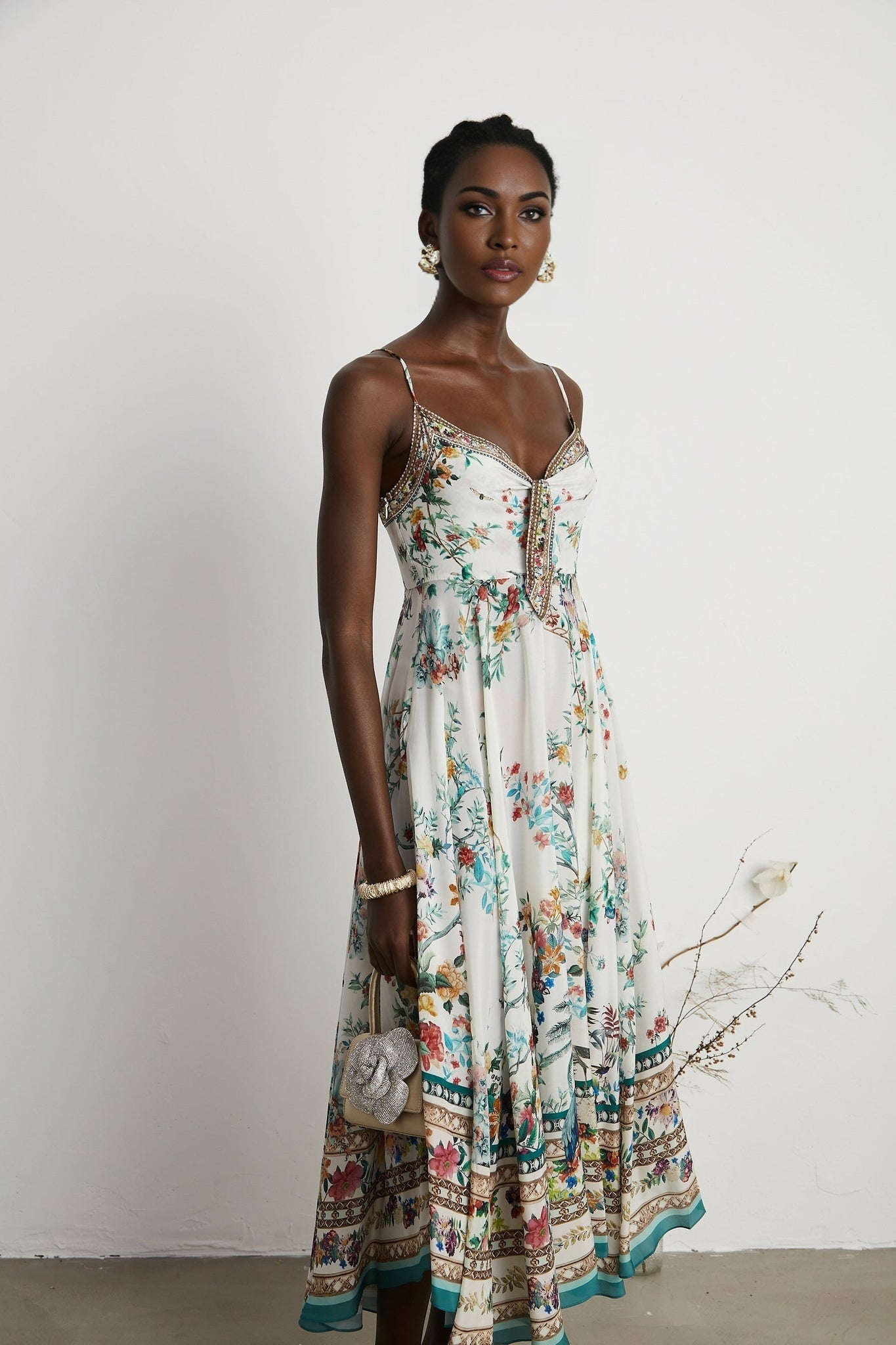 A floral print midi dress with embellishments inspired by Philippine design featuring a colorful pattern and decorative details on a flowing silhouette