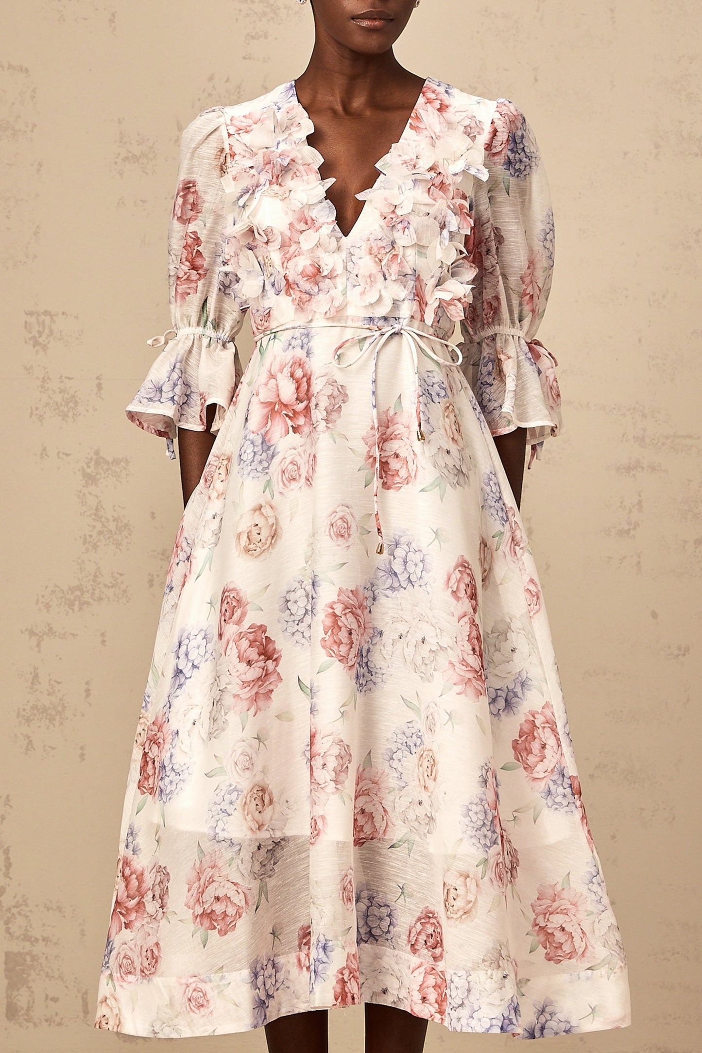 A floral print midi dress with three dimensional petal details featuring a Téa design