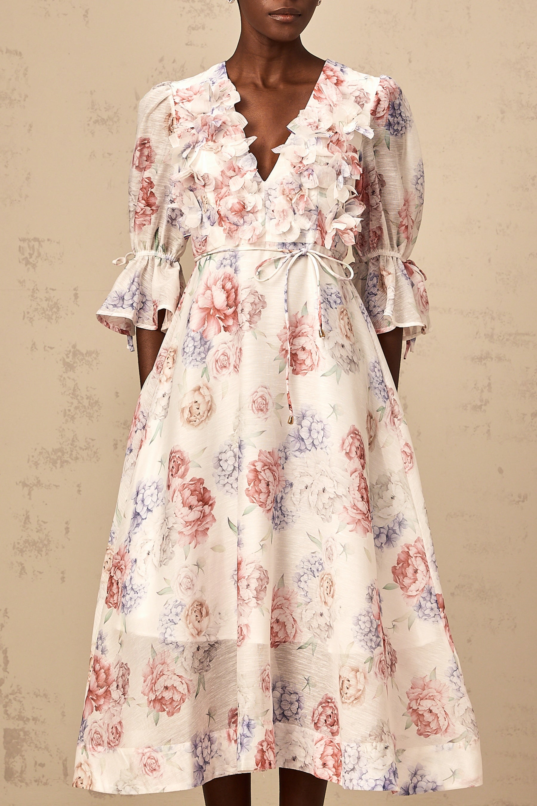 A floral print midi dress with three dimensional petal details featuring a Téa design