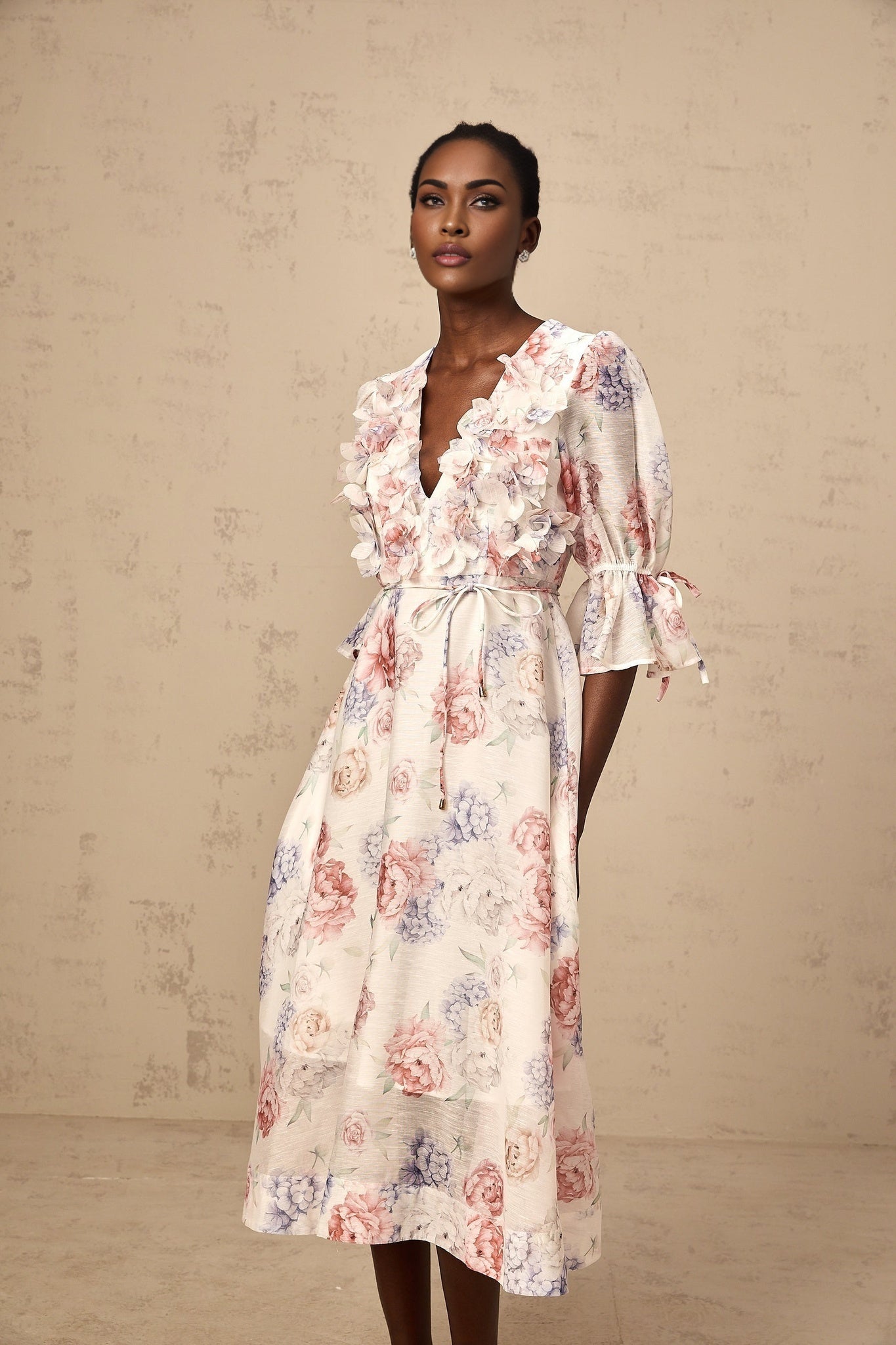 A floral print midi dress with threedimensional petal details featuring a vibrant pattern on a lightweight fabric with a flowing silhouette