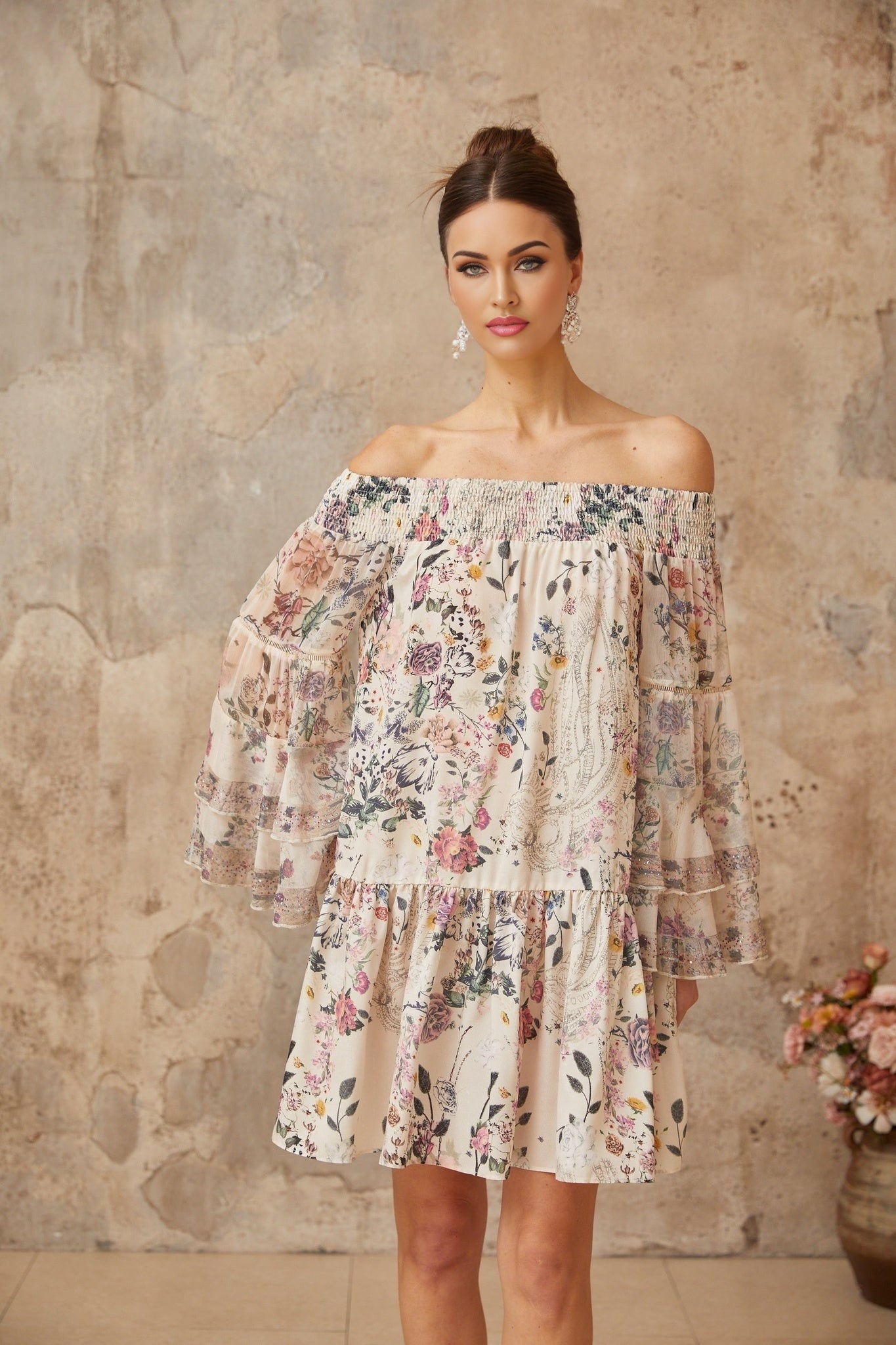 A floral print mini dress with smocked detailing named Yasmine featuring a short length and a vibrant pattern