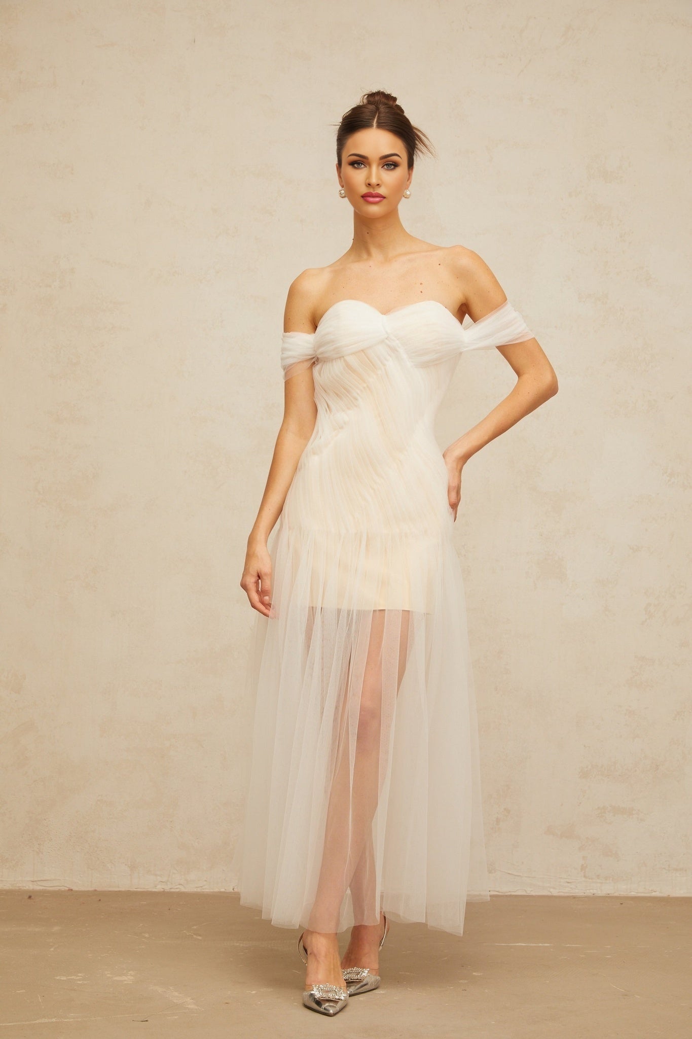 A flowing off white maxi dress with pleated tulle fabric and a long skirt