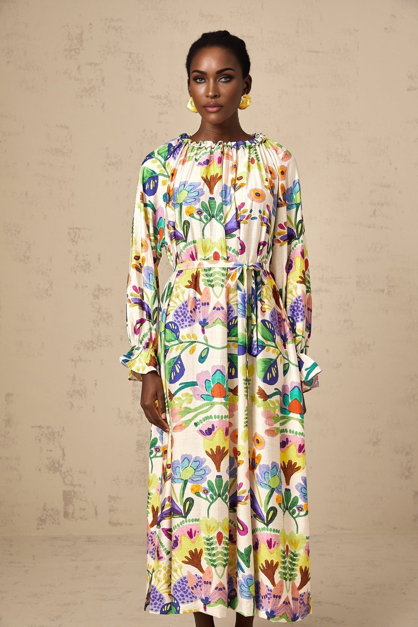 A flowy midi dress with a colorful paisley print pattern on white poplin fabric featuring a feminine silhouette and comfortable fit