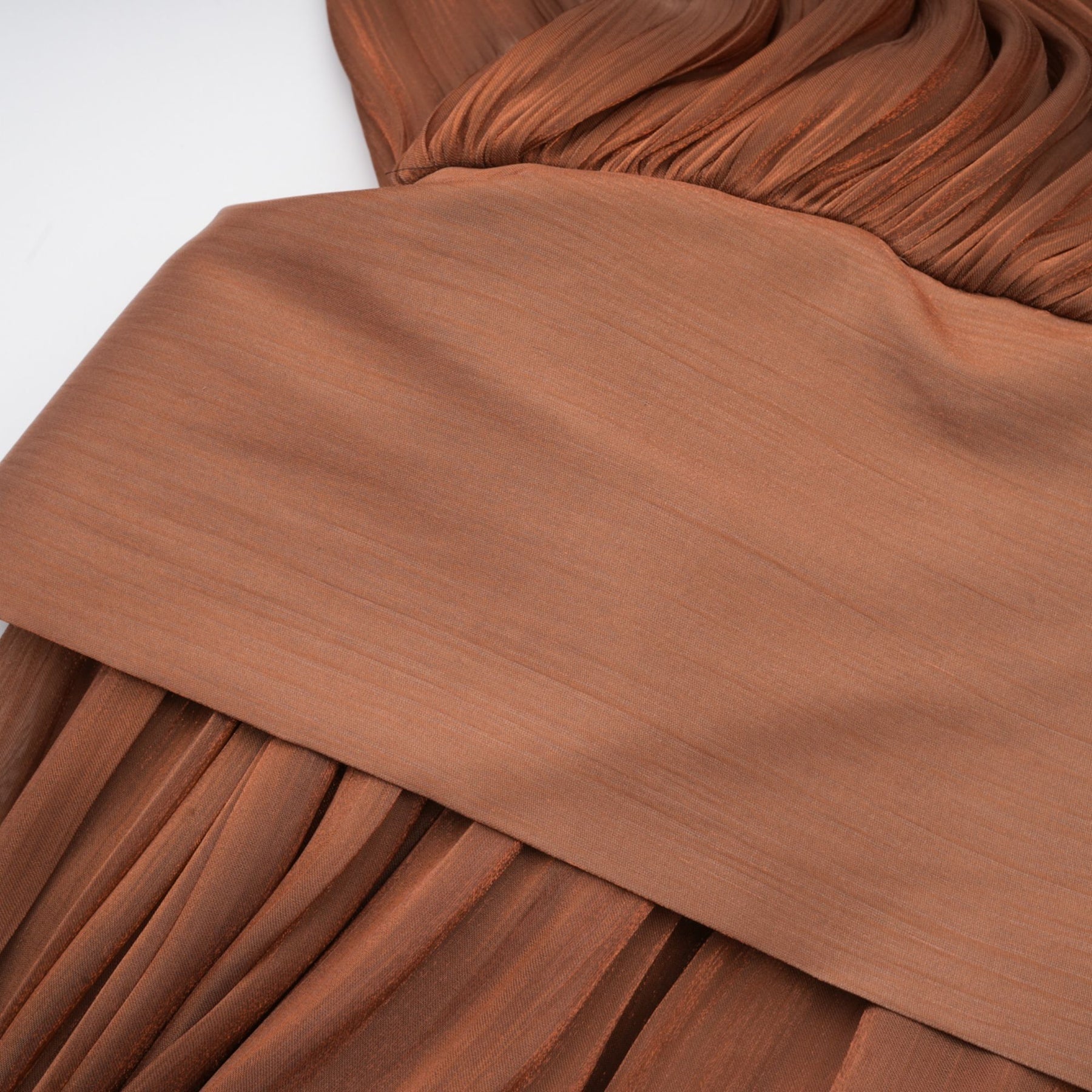 A fulllength brown satin maxi dress with pleated details and a flowing silhouette