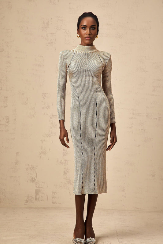A gold colored midi dress with a ribbed knit texture and delicate pointelle pattern worn by a model standing against a plain background