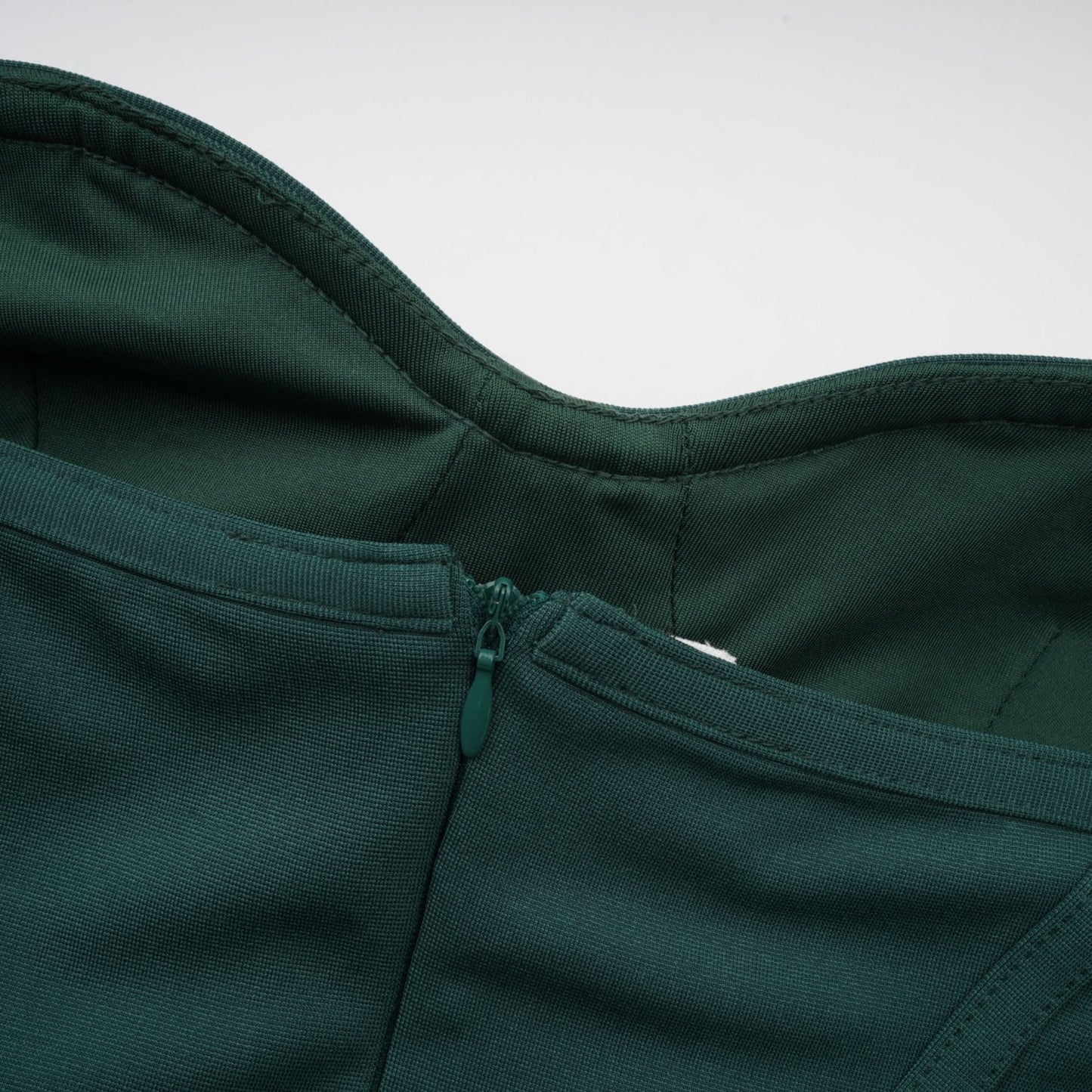 A green maxi dress with corsetstyle bodice featuring ribbon designs and a long flowing skirt