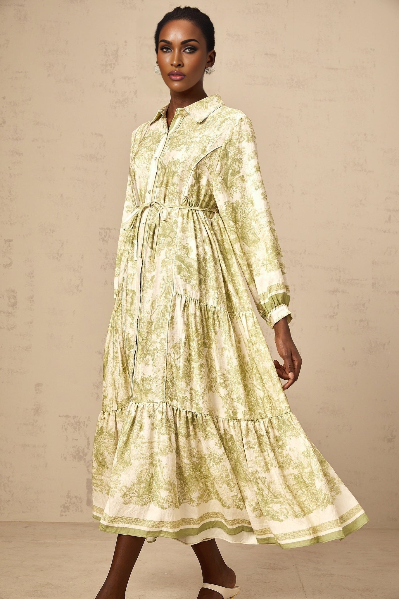 A green midi dress with a graphic print pattern named Adelaide worn by a model standing in a neutral background